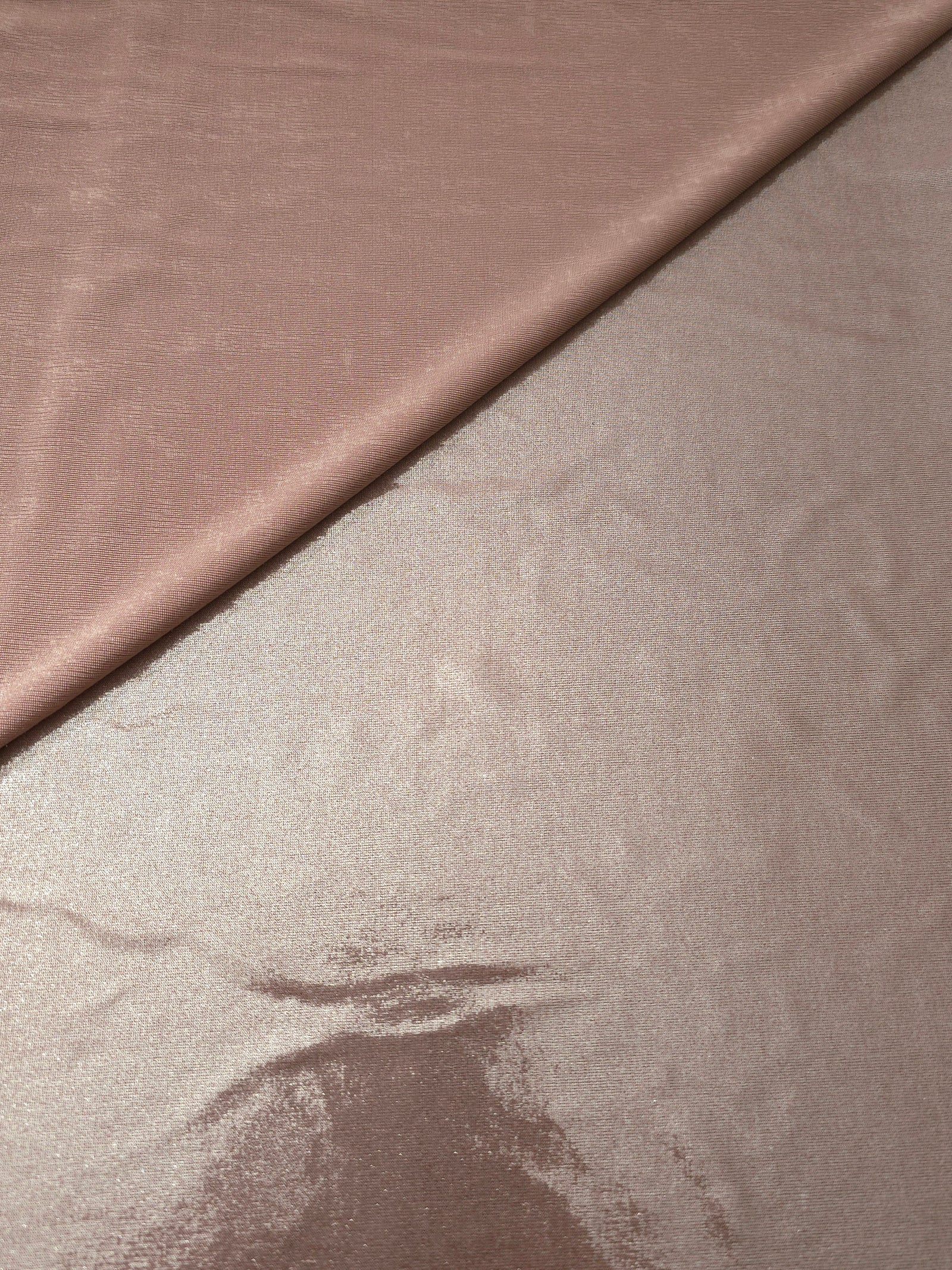 Gently folded Dusty Rose Taupe shimmer spandex fabric showing luminous foil finish for tops, skirts and occasion garments