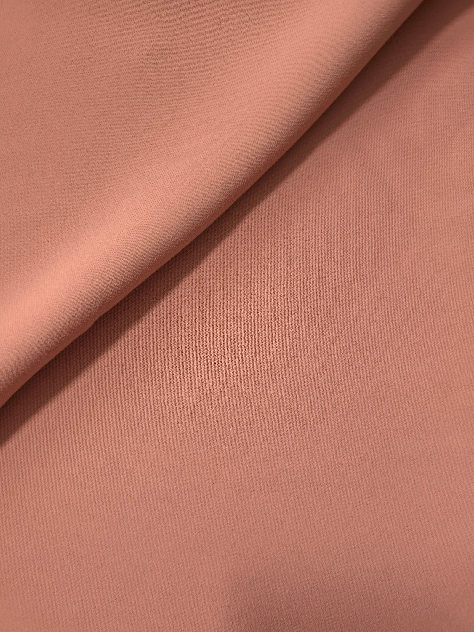 Dusty Rose Taupe opaque Korean polyester crepe in a soft fold, showing flowing drape for garment making