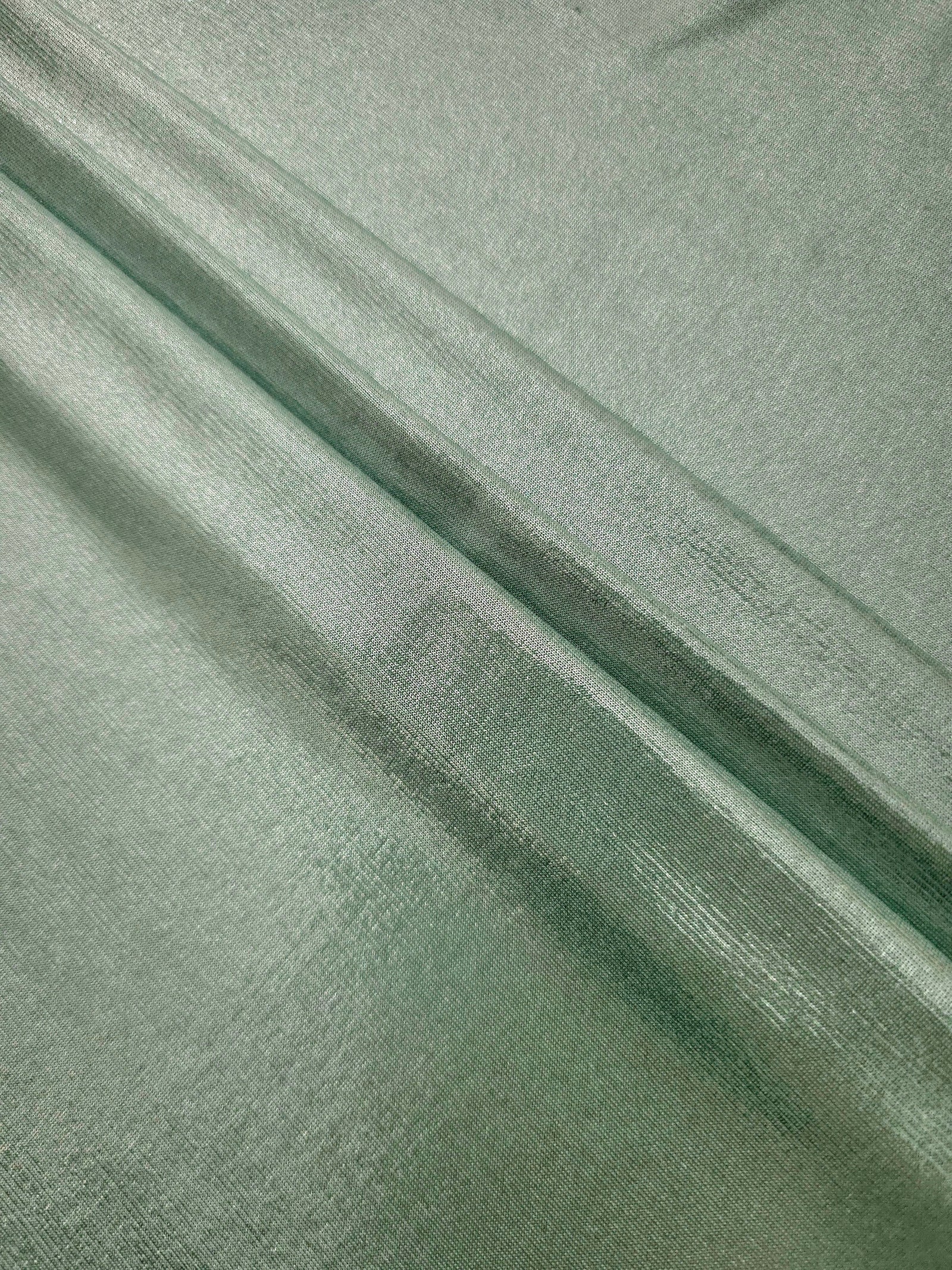Layered Dusty Sage Green shimmer stretch fabric showing metallic foil depth and soft structure for costumes, skirts and fashion apparel