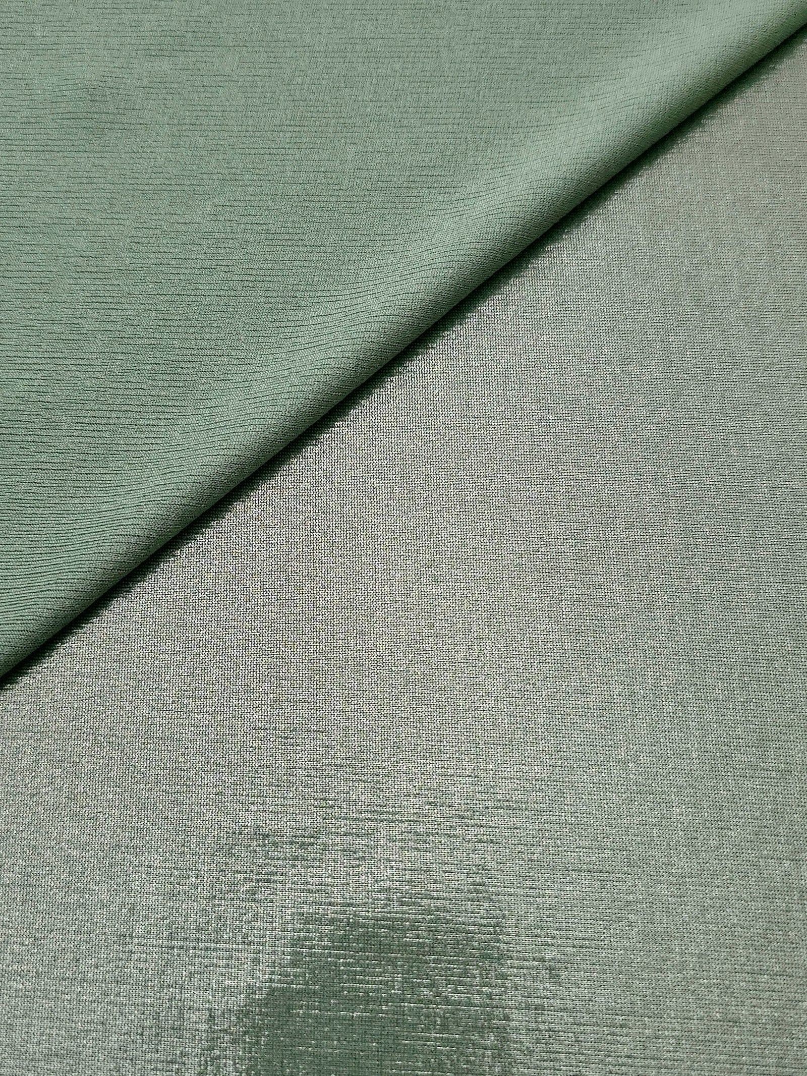 Dusty Sage Green shimmer spandex in a soft fold, showing metallic foil sheen and flexible drape for tops, skirts and costumes