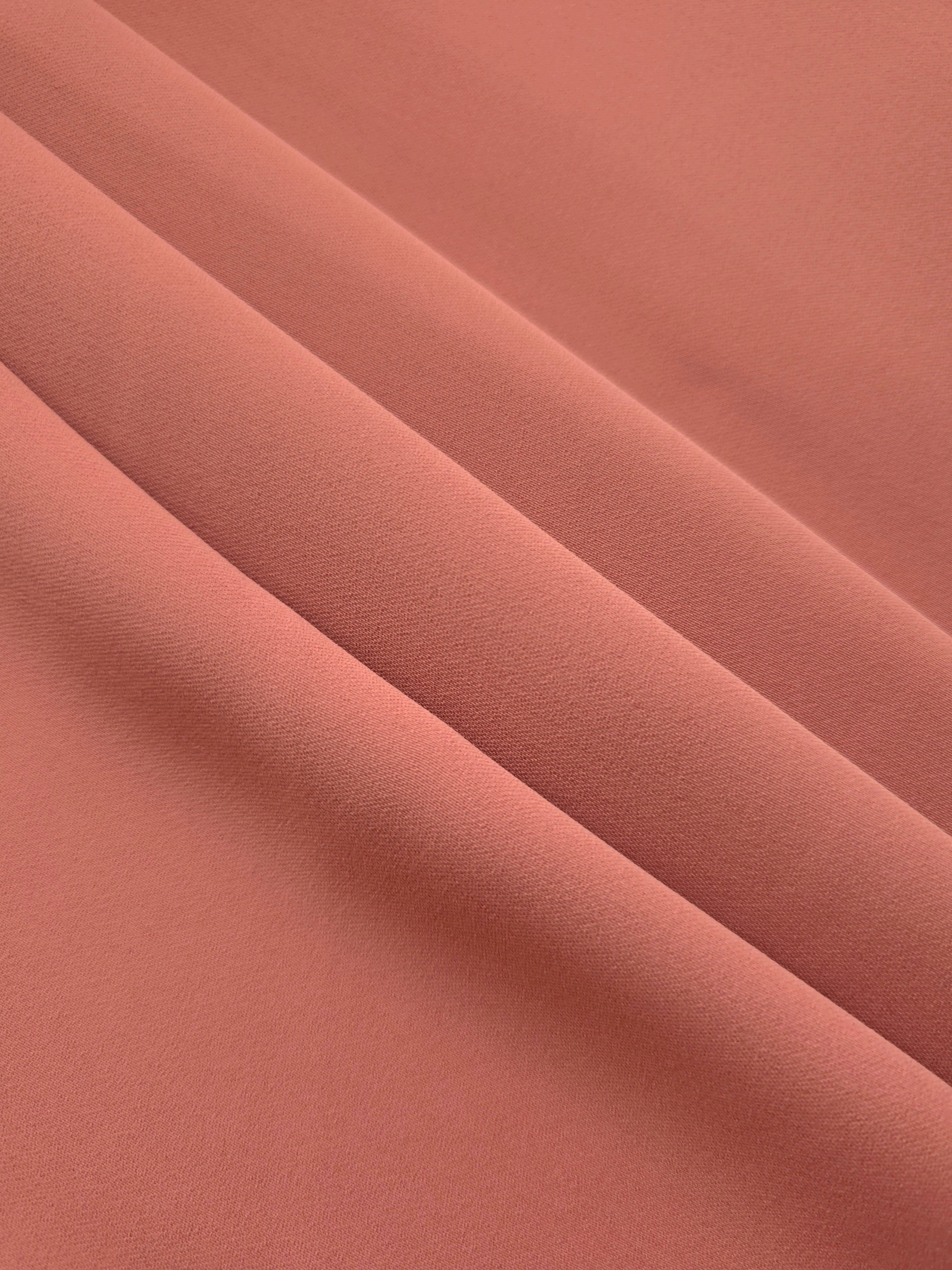 Layered Dusty Terracotta mechanical polyester crepe showing gentle stretch and soft structure for dressmaking