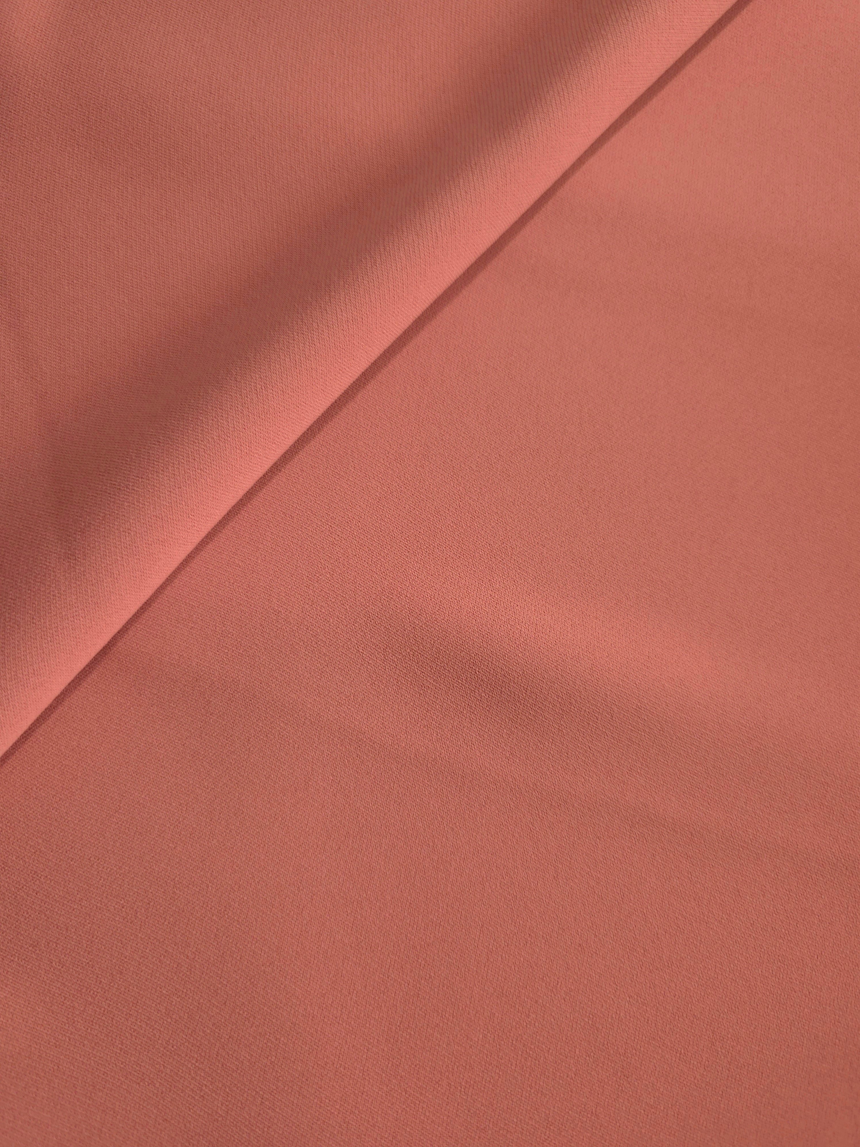 Dusty Terracotta polyester crepe in a soft fold, showing flowing drape for garment making and dressmaking