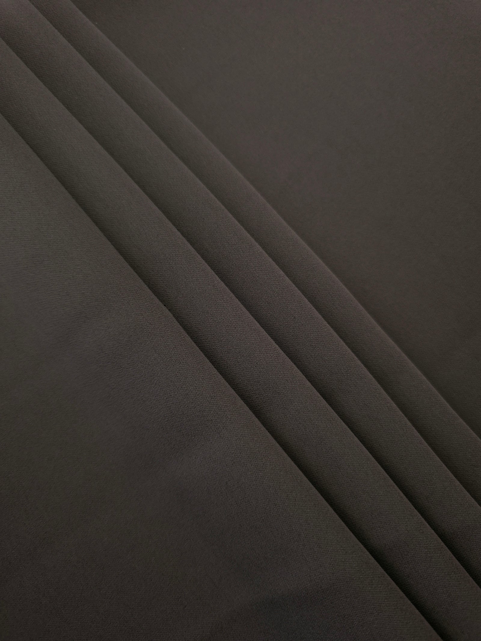 Espresso Taupe Korean crepe in layered folds, showing soft structure and slight mechanical stretch for skirts