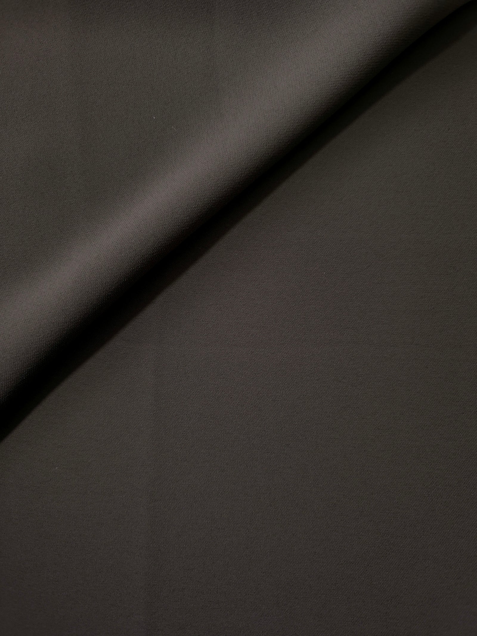 Soft fold of Espresso Taupe opaque polyester crepe showing fluid dressmaking drape for dresses and skirts