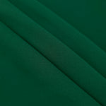 Forest Green mechanical polyester crepe in layered folds, showing gentle stretch and structure for dressmaking