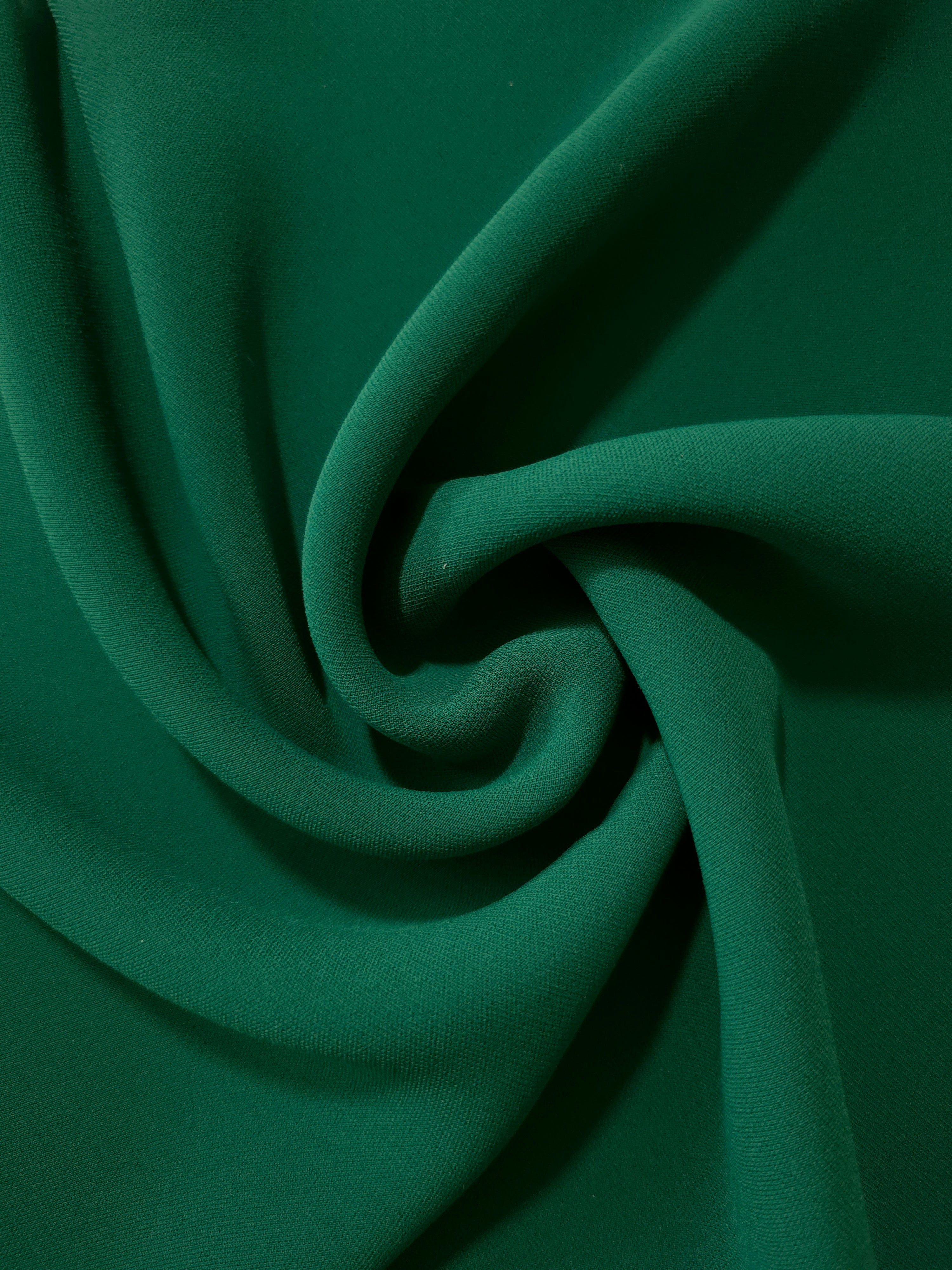 Spiral styling of Forest Green Korean polyester crepe showing supple drape for abayas, dresses and occasionwear