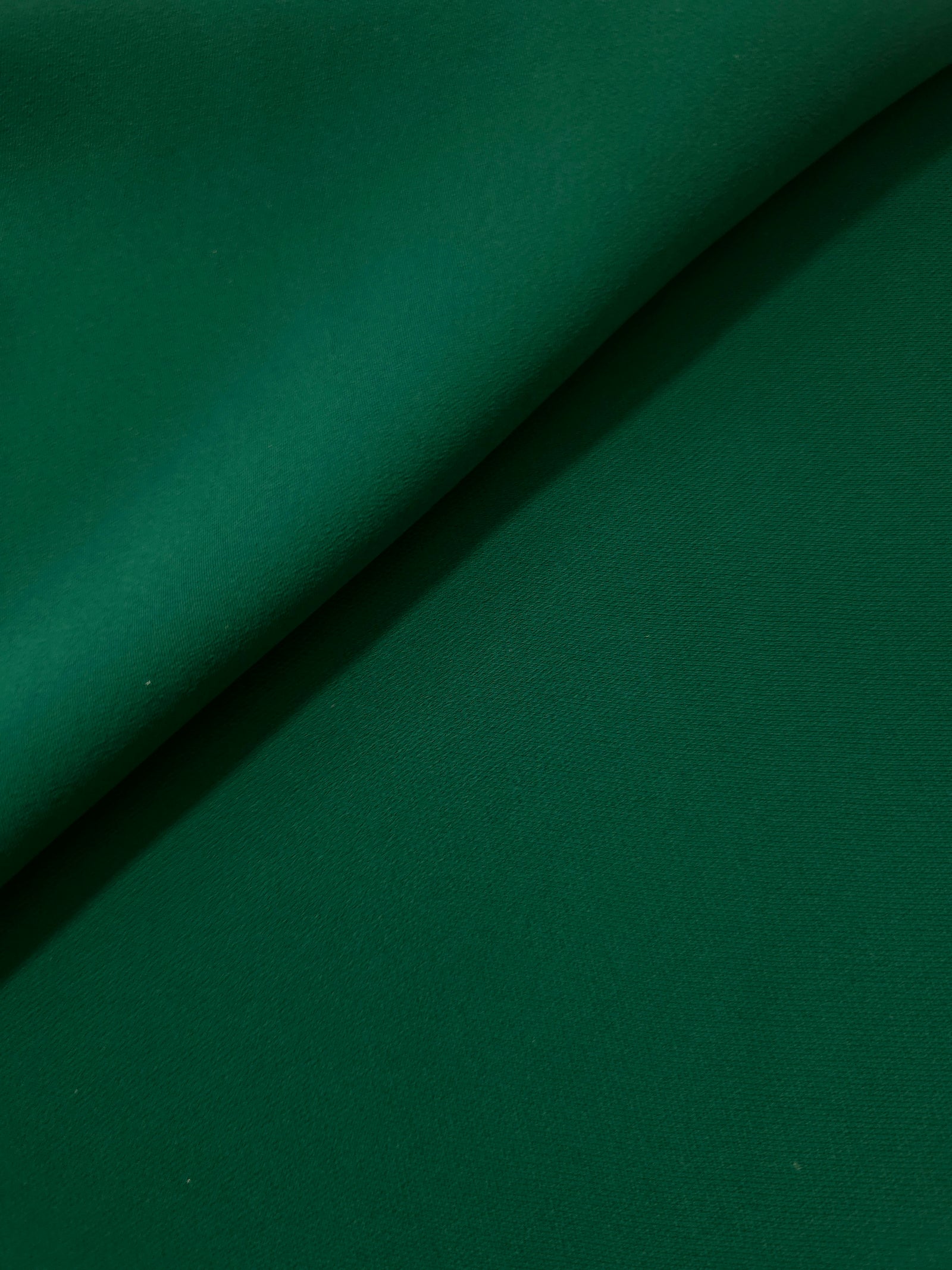 Forest Green polyester crepe gathered into a soft fold, showing fluid drape for dresses and blouse making