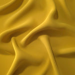 Draped folds of Golden Ochre polyester crepe showing opaque coverage and fluid movement for garment making