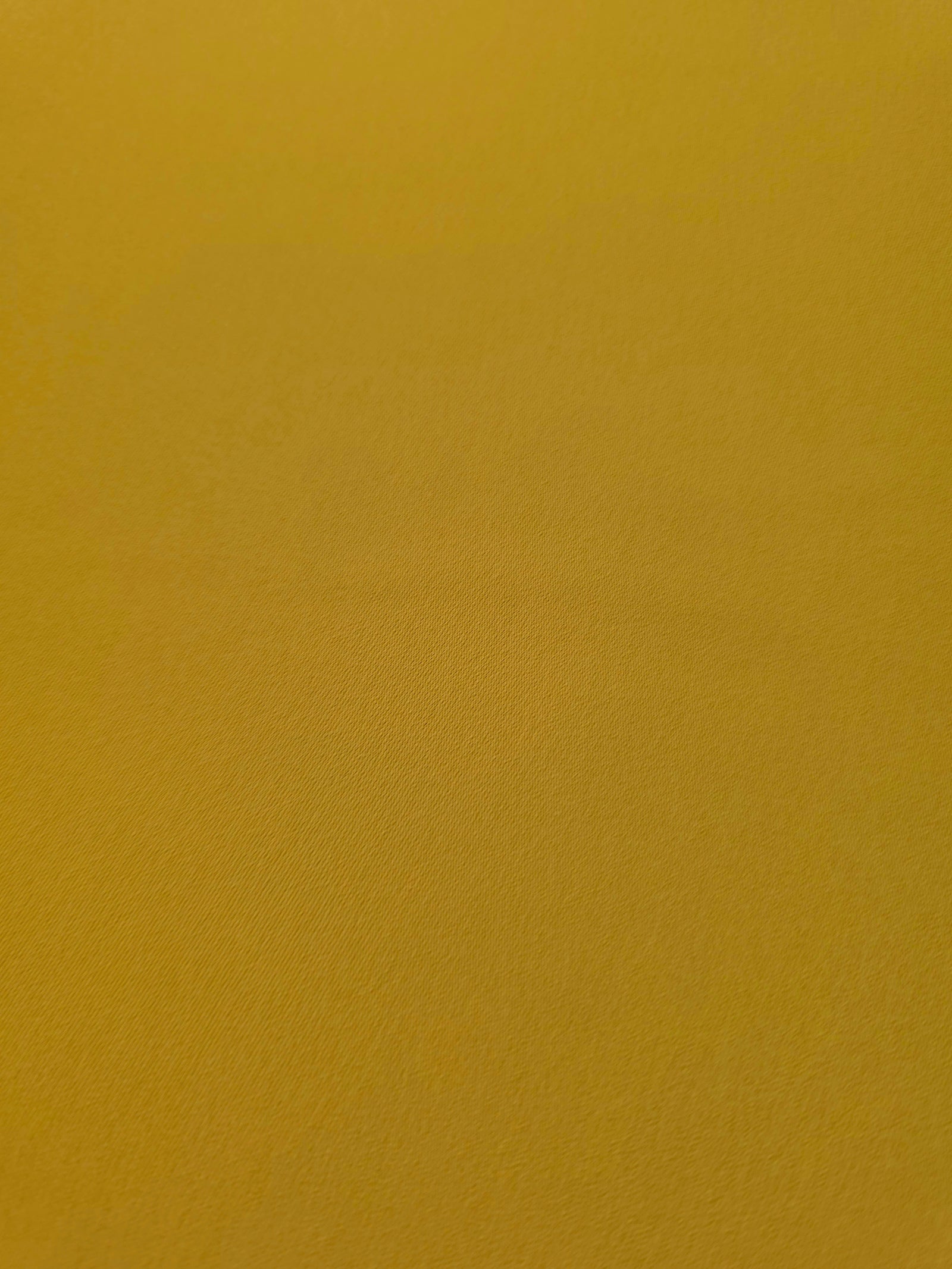 Golden Ochre mechanical polyester crepe in close-up, showing fine woven texture and a silky-soft surface