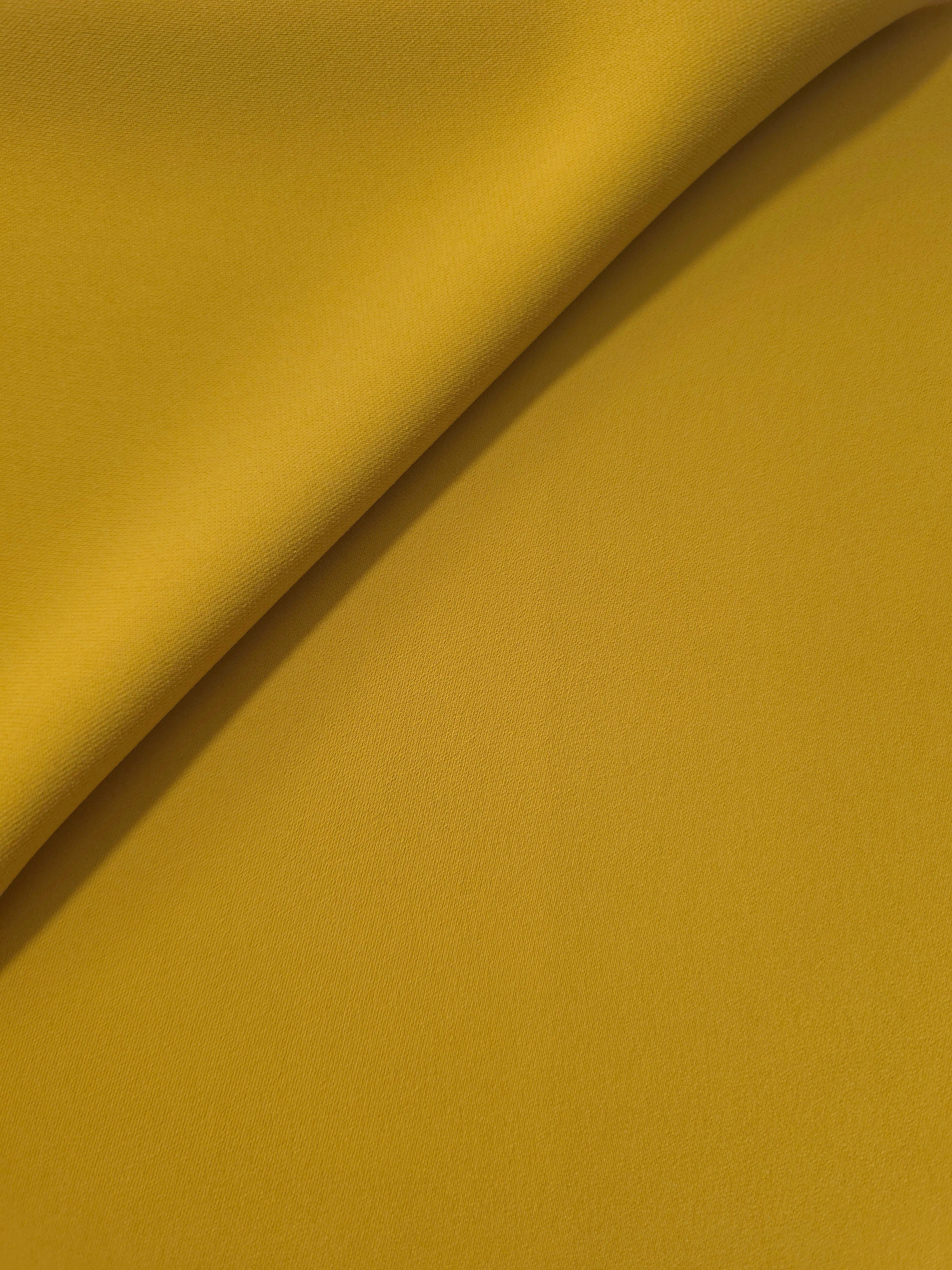 Golden Ochre opaque Korean polyester crepe in a soft fold, showing flowing drape for garment making