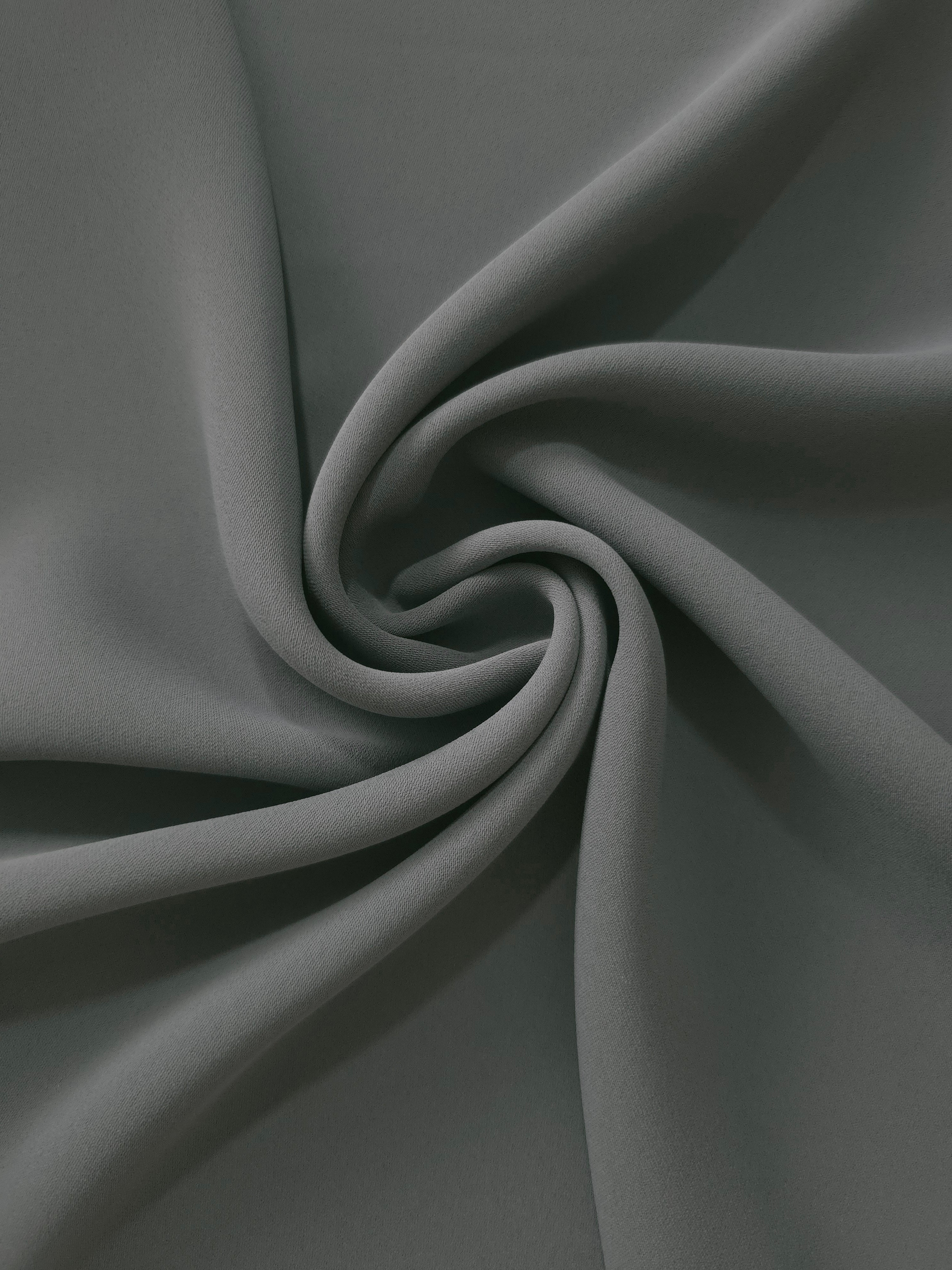 Graphite Gray silky-feel polyester crepe in a flowing swirl, showing drape for abayas and modest fashion