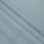 Layered folds of Ice Blue 100% mechanical polyester crepe showing body and gentle construction stretch