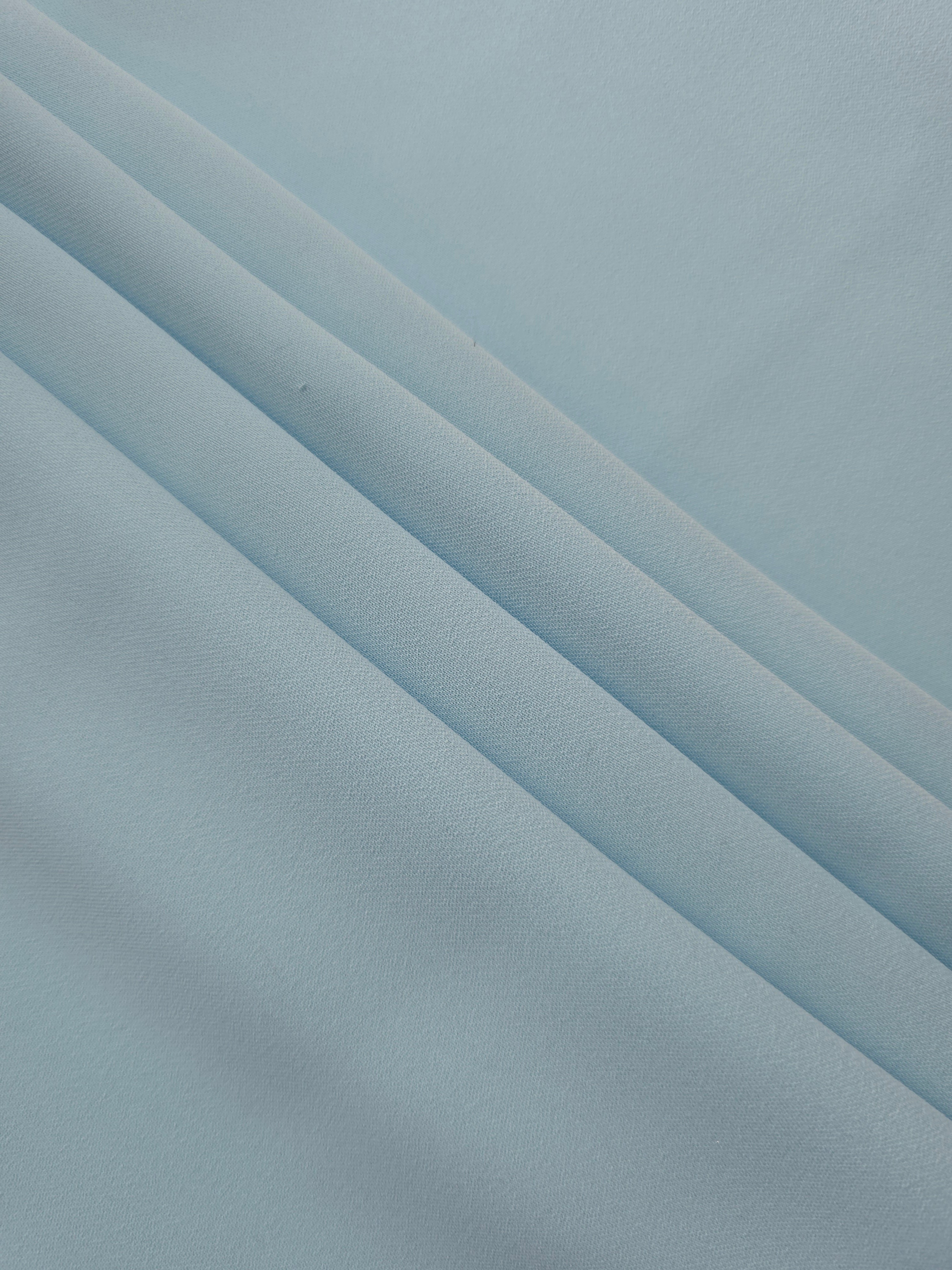 Layered folds of Ice Blue 100% mechanical polyester crepe showing body and gentle construction stretch
