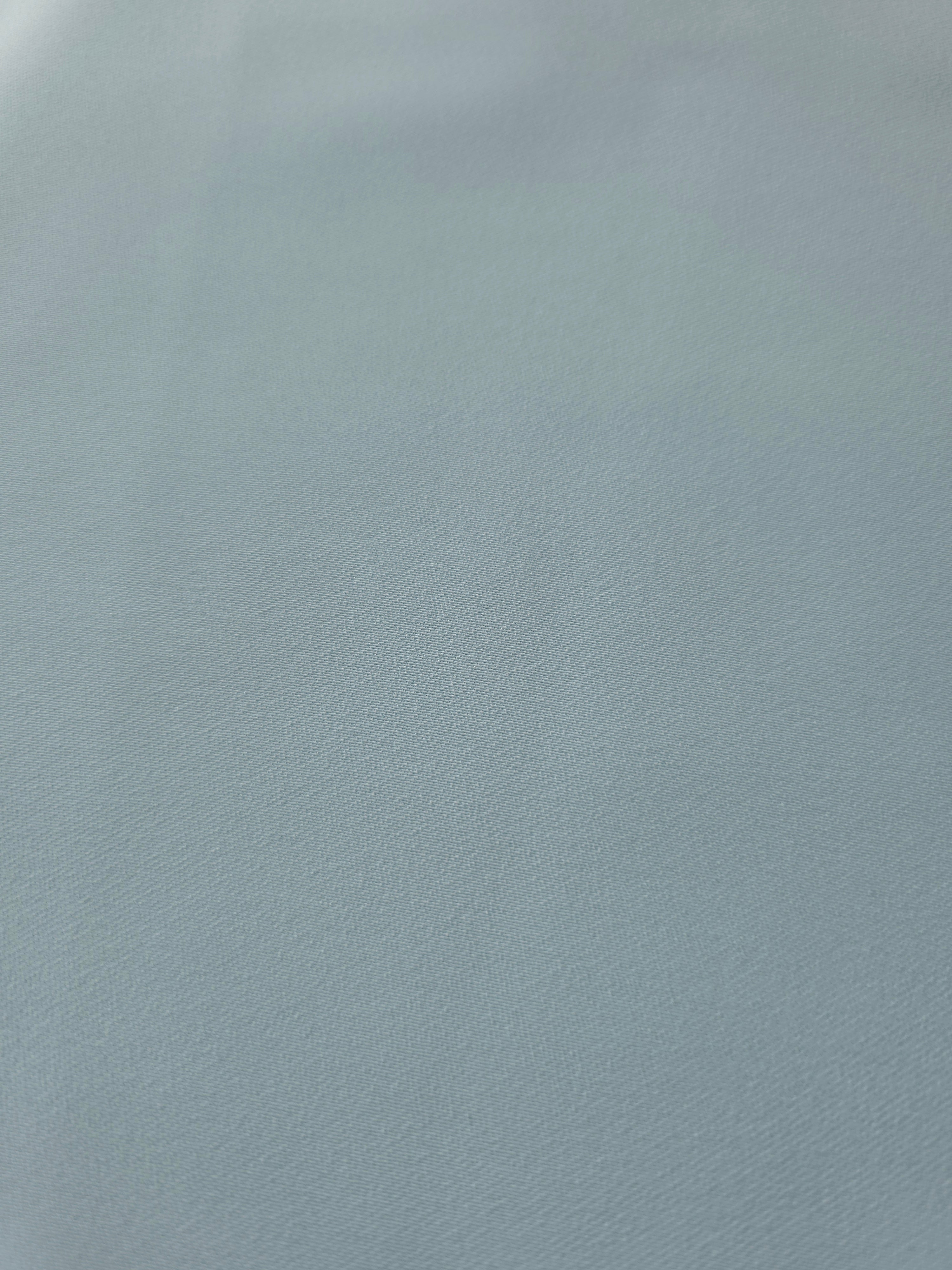 Texture detail of Ice Blue mechanical polyester crepe, a smooth woven fabric with a soft silky hand