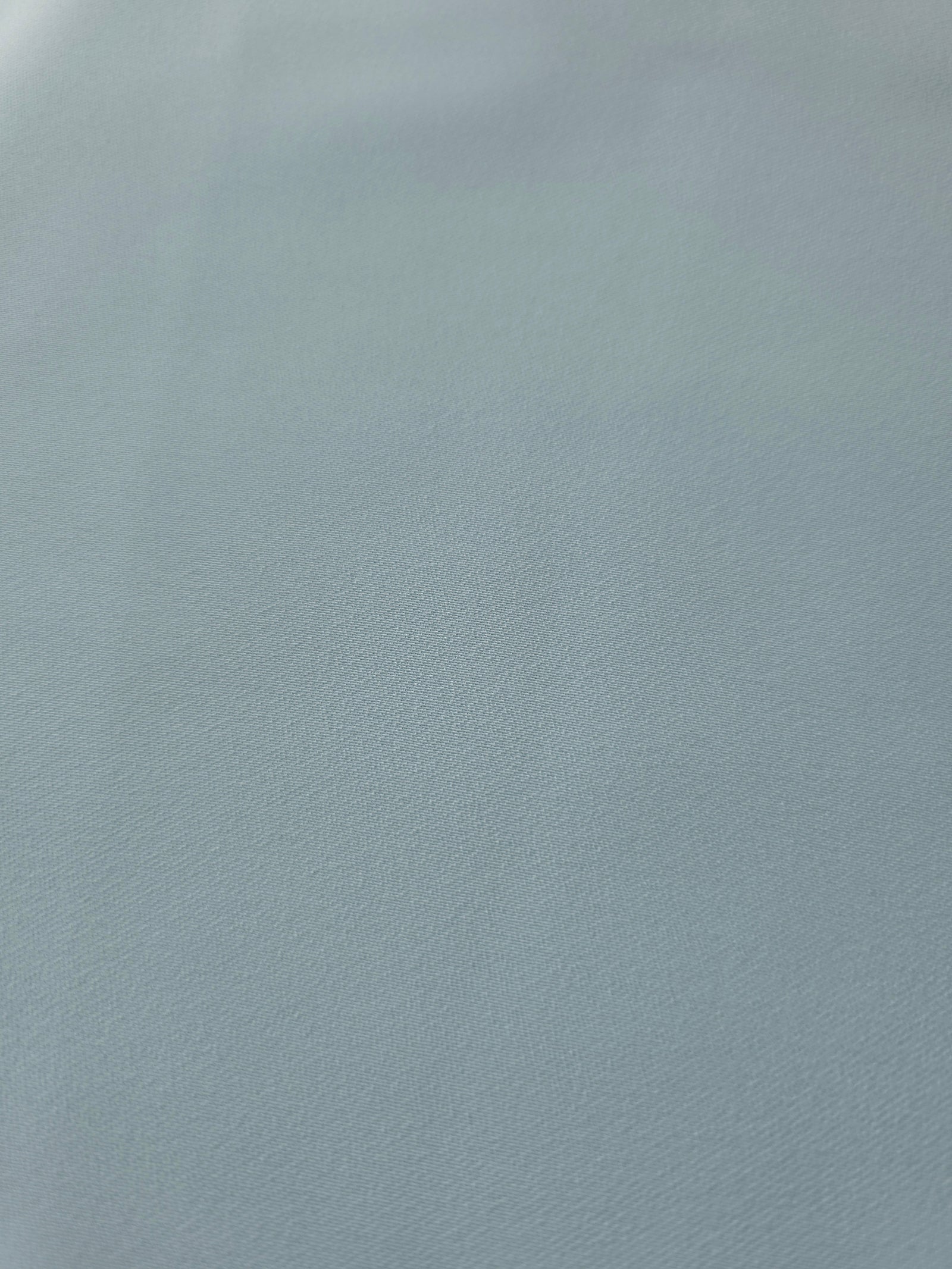 Texture detail of Ice Blue mechanical polyester crepe, a smooth woven fabric with a soft silky hand