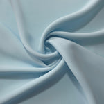 Ice Blue opaque polyester crepe in a spiral drape, showing flowing form for skirts and modest garments