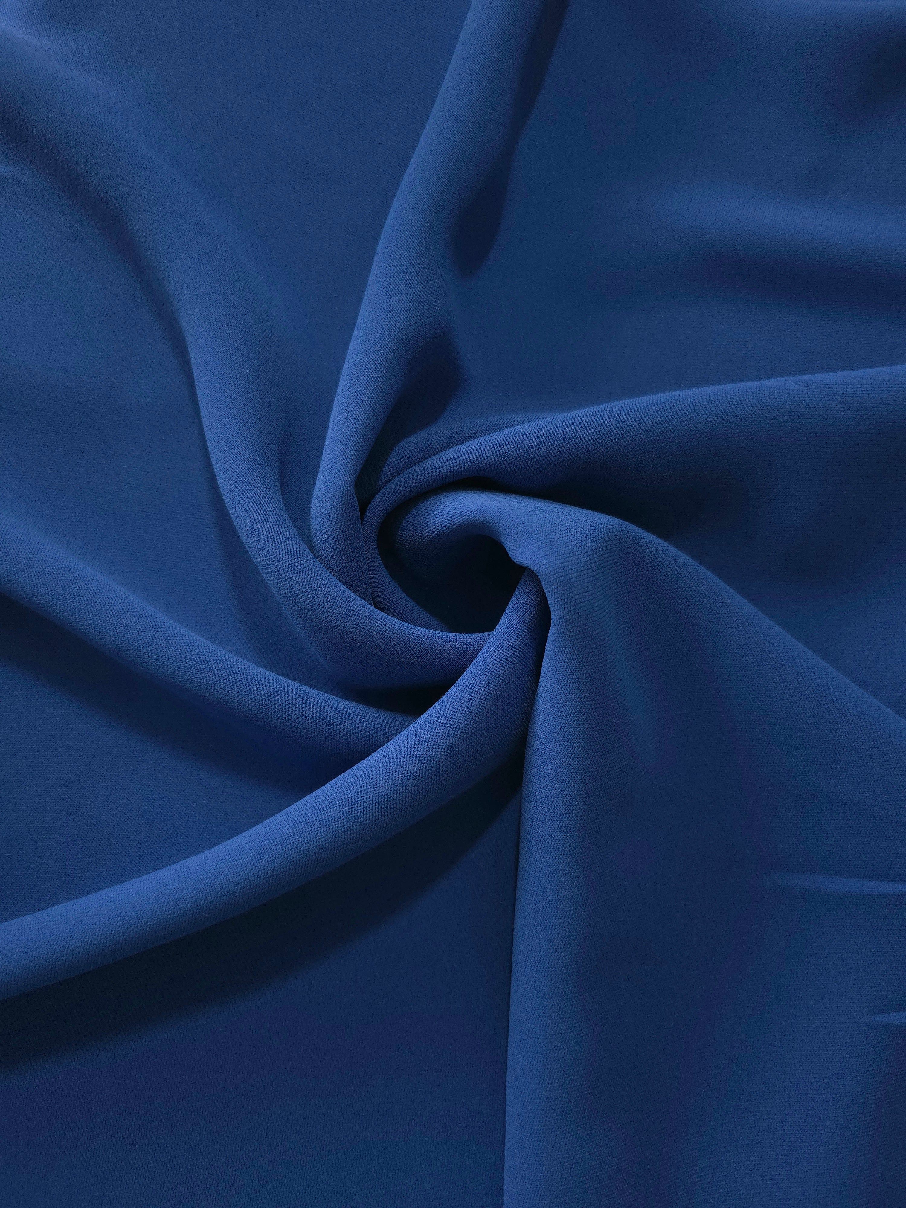 Indigo Navy Blue silky-feel polyester crepe in a flowing swirl, showing drape for abayas and occasionwear