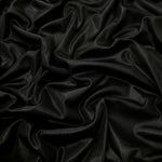 Jet Black shimmer stretch fabric in draped folds, highlighting metallic foil sheen for evening dresses, costumes and statement apparel