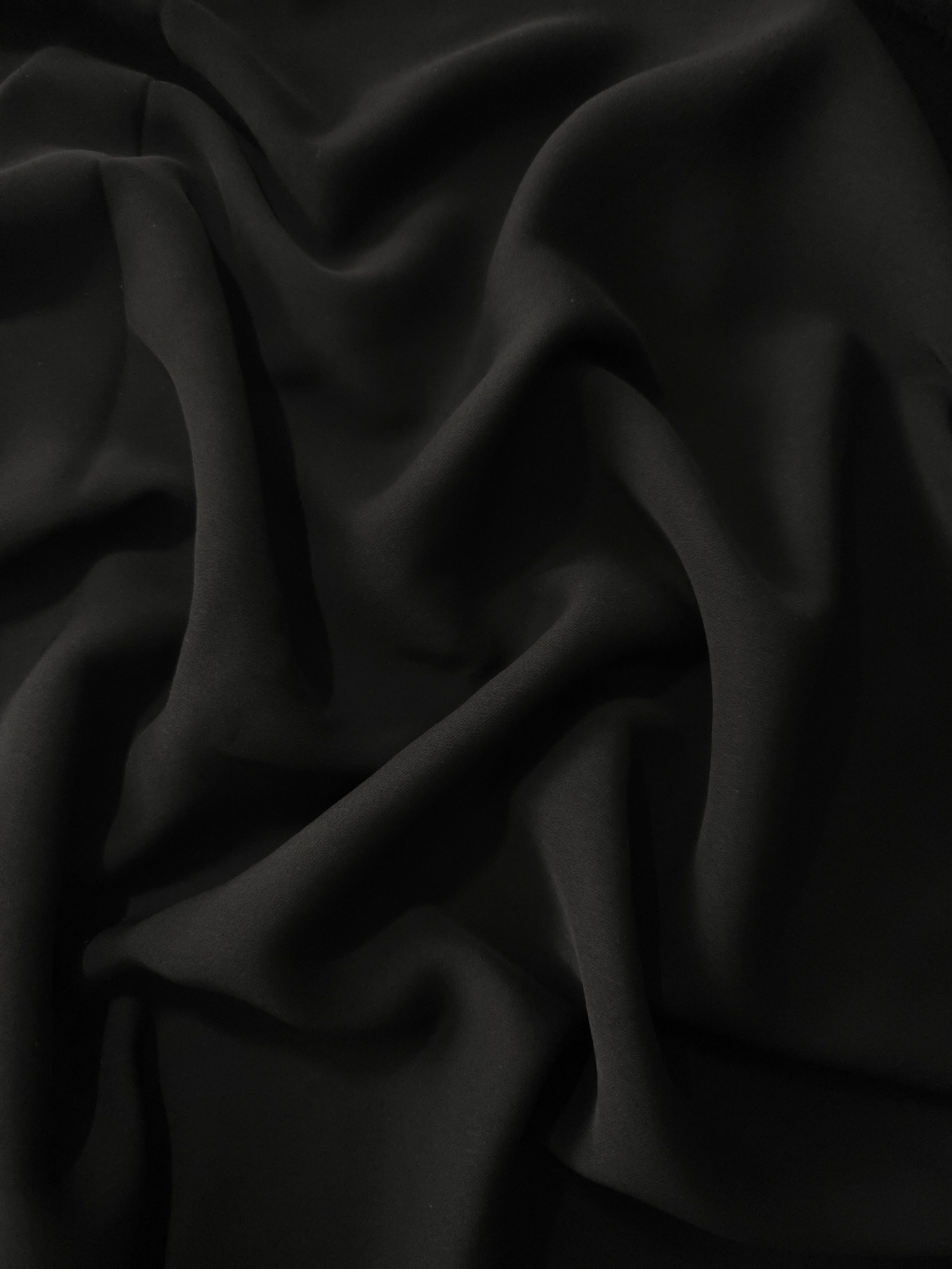 Long draped folds of Jet Black polyester crepe showing flowing coverage for abayas, dresses and elegant apparel