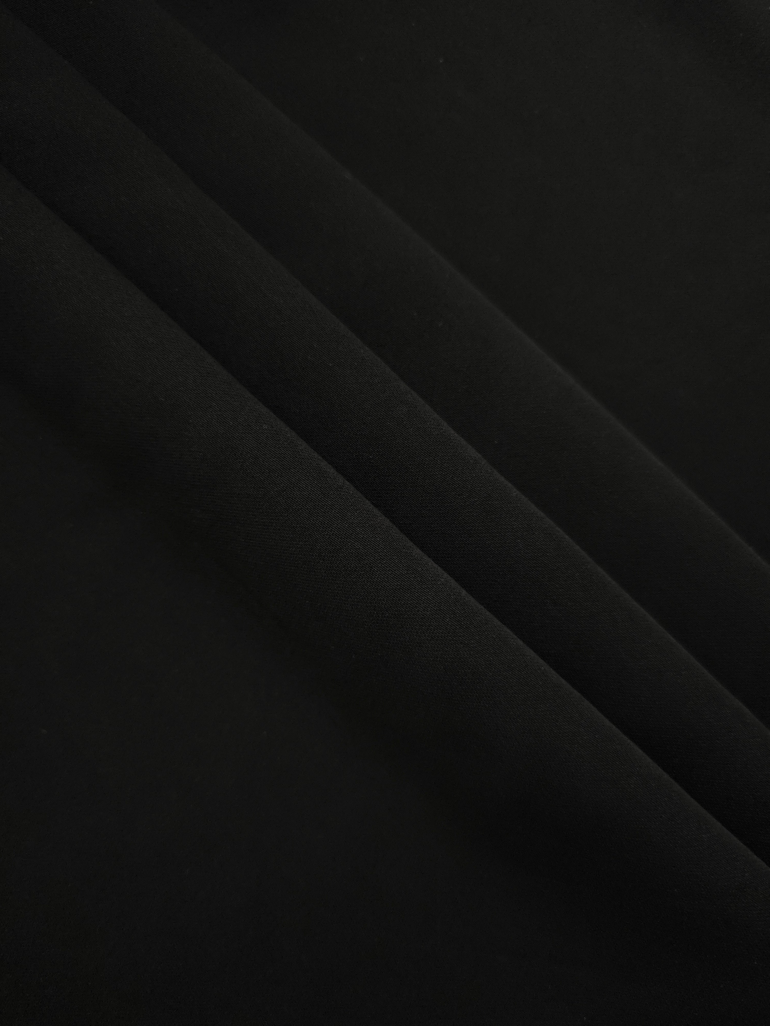 Layered Jet Black mechanical polyester crepe showing soft body and gentle stretch for dressmaking and tailoring