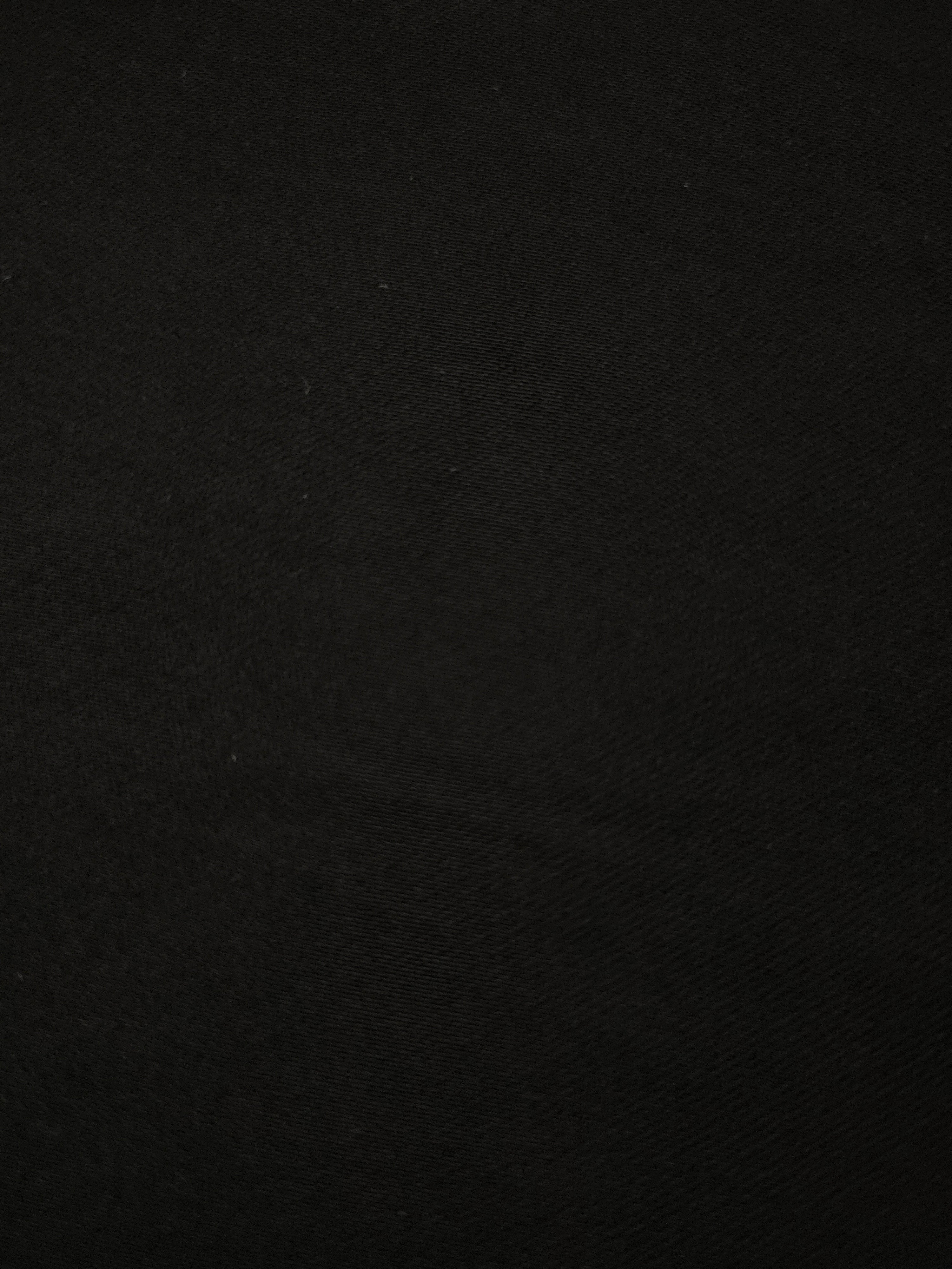 Fine close-up of Jet Black mechanical polyester crepe showing smooth woven texture and a silky-soft hand