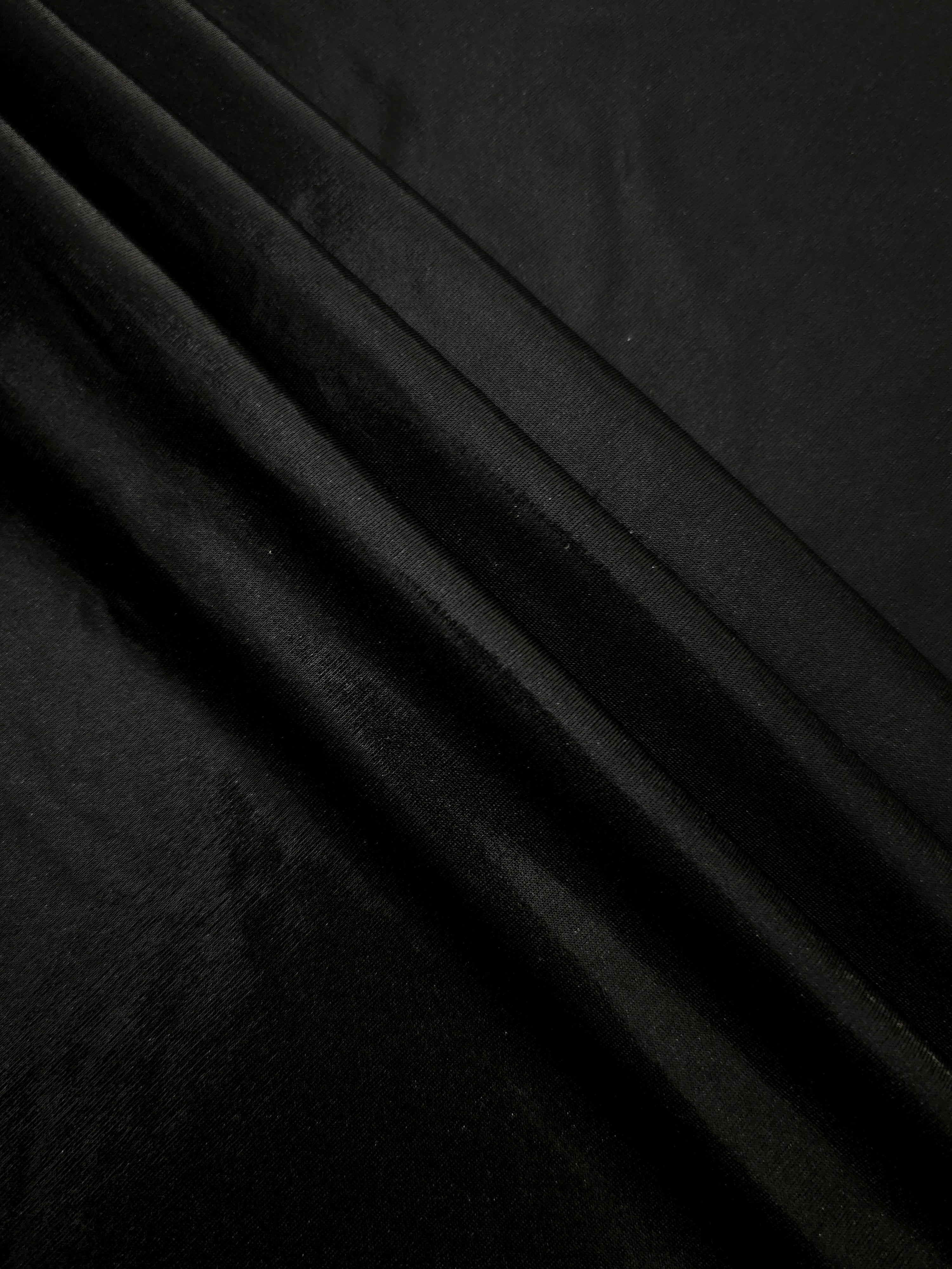 Jet Black metallic foiled spandex in layered folds, highlighting reflective texture and flexible structure for stage and eveningwear