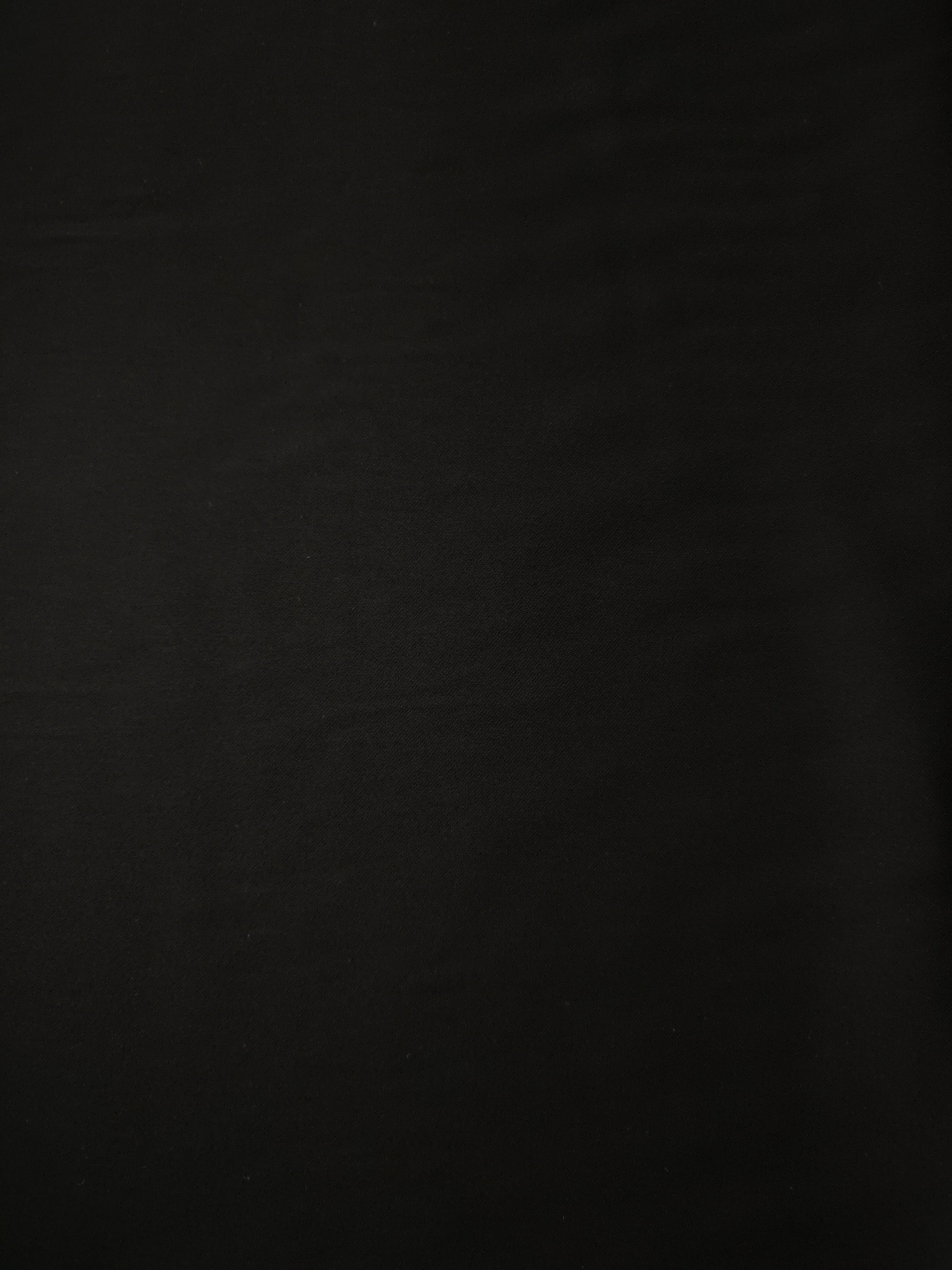 Jet Black Italian polyester crepe shown flat, smooth apparel fabric for dresses, separates and formalwear