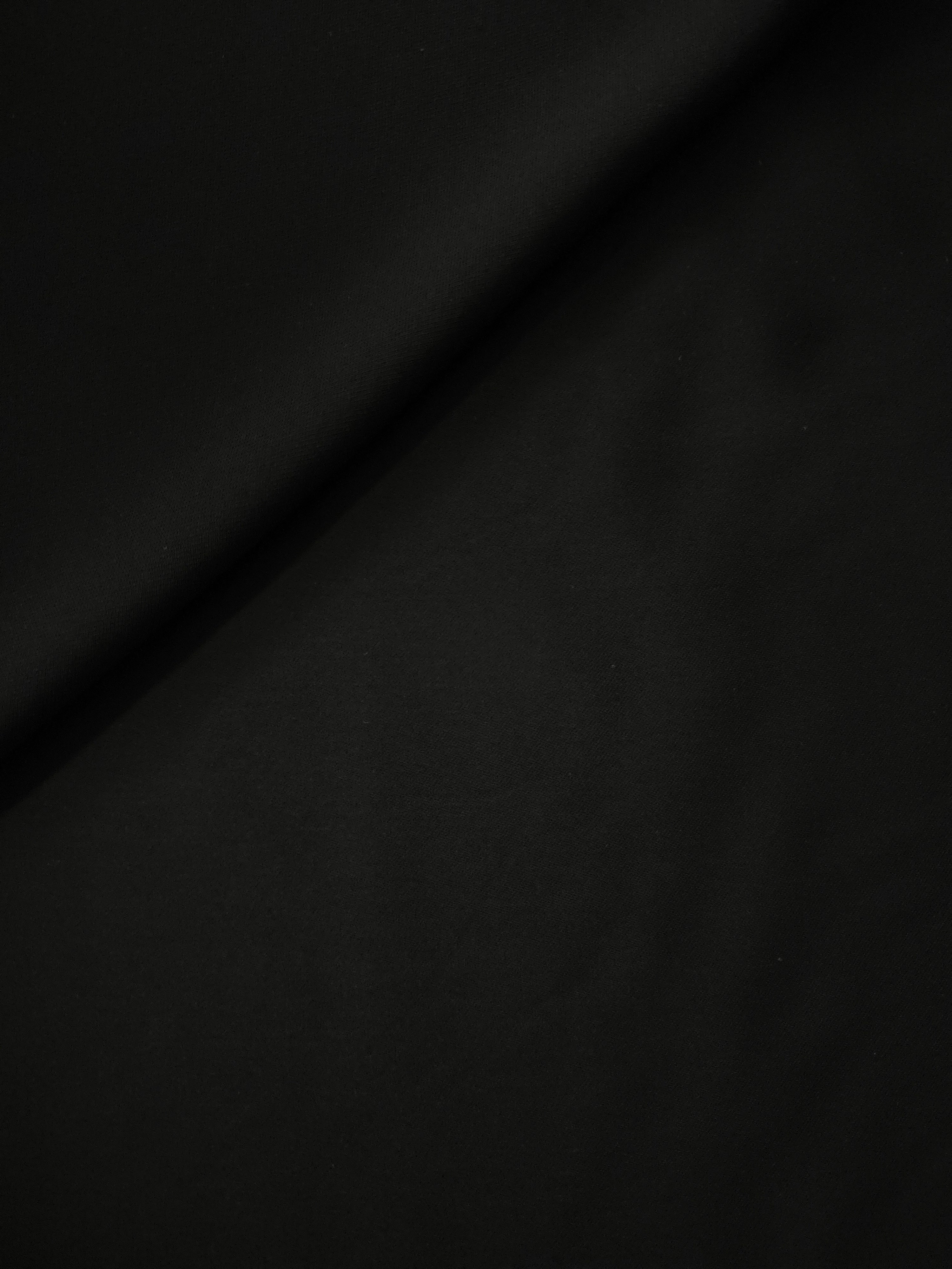 Jet Black polyester crepe in a soft fold, showing fluid drape for evening dresses, blouses and skirts