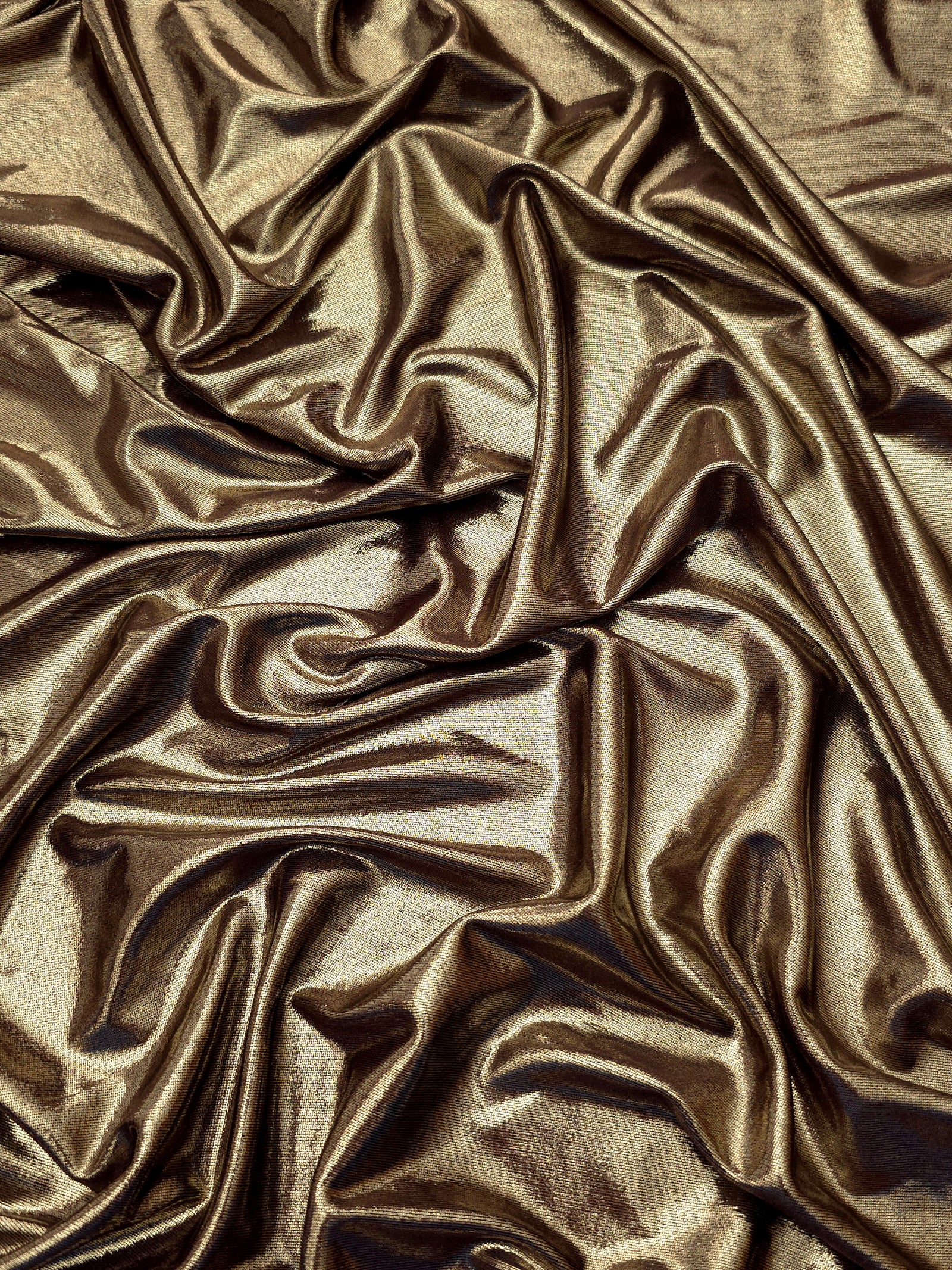 Flowing folds of Khaki Taupe metallic foiled spandex, showing shimmer and drape for dancewear, party dresses and performance fashion