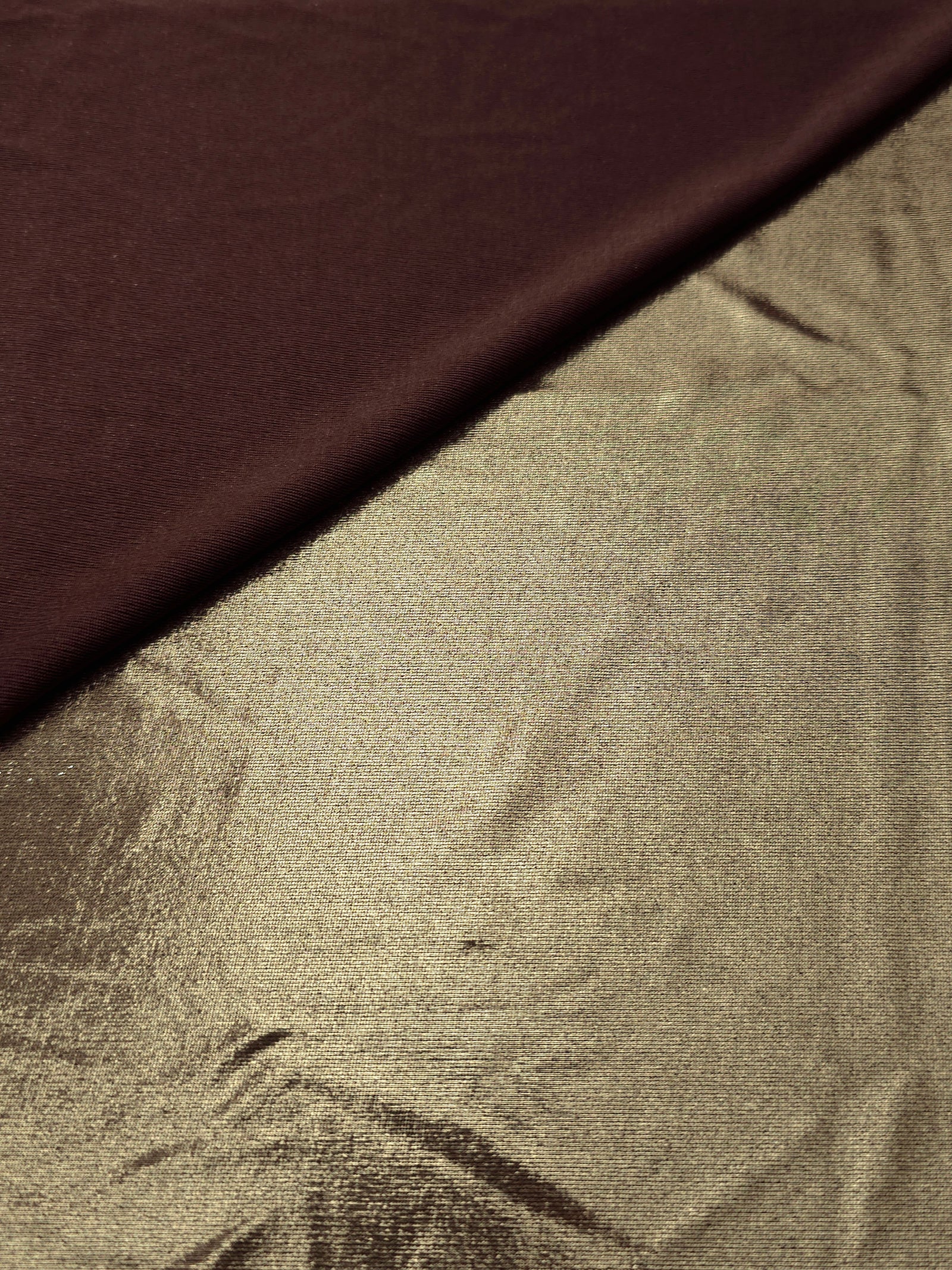 Khaki Taupe foiled stretch fabric in a gentle fold, showing metallic shimmer and flexibility for partywear and performance fashion