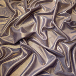 Flowing folds of Lavender Taupe metallic foiled spandex, showing shimmer and drape for dancewear, party dresses and performance fashion