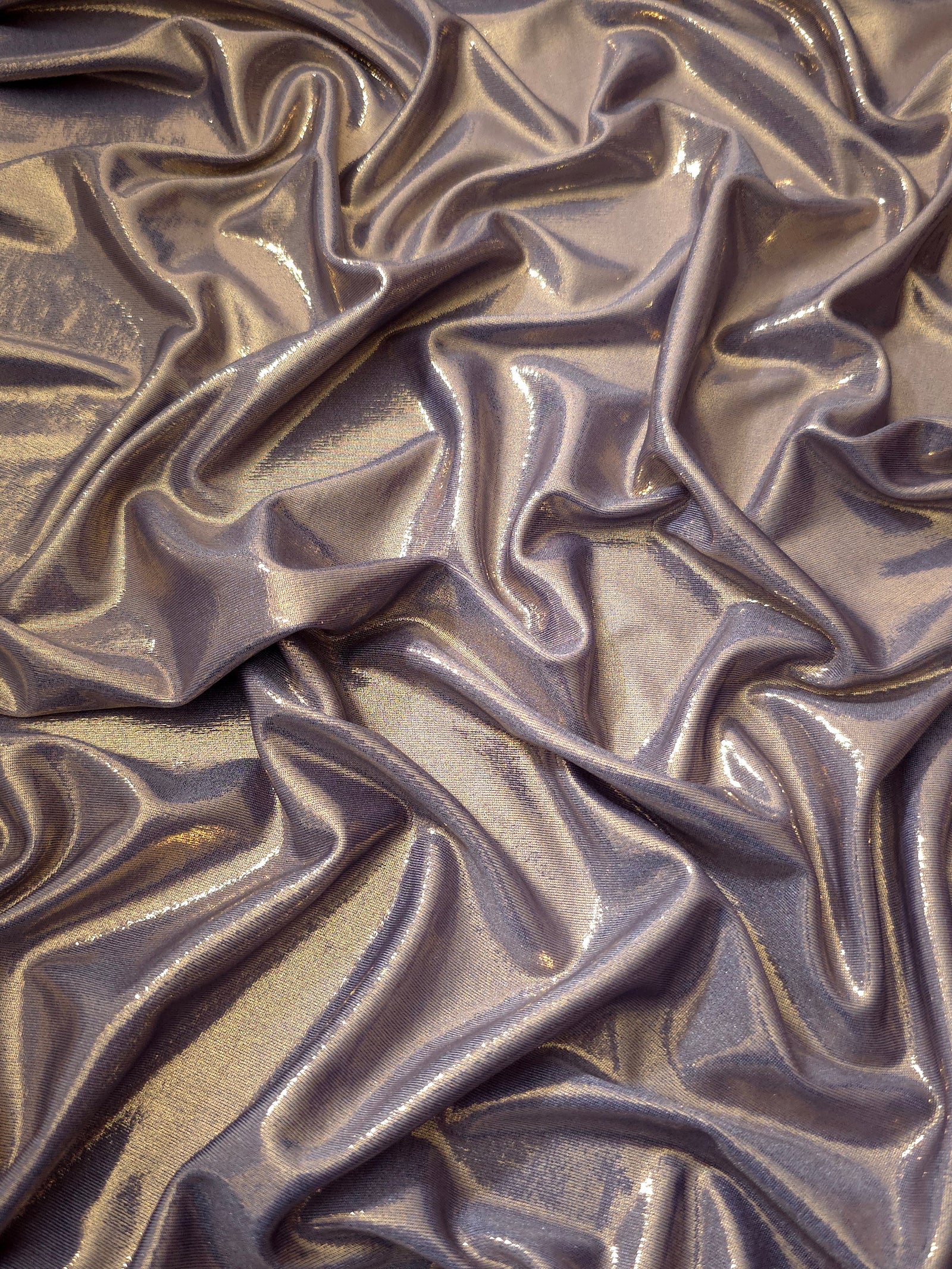 Flowing folds of Lavender Taupe metallic foiled spandex, showing shimmer and drape for dancewear, party dresses and performance fashion