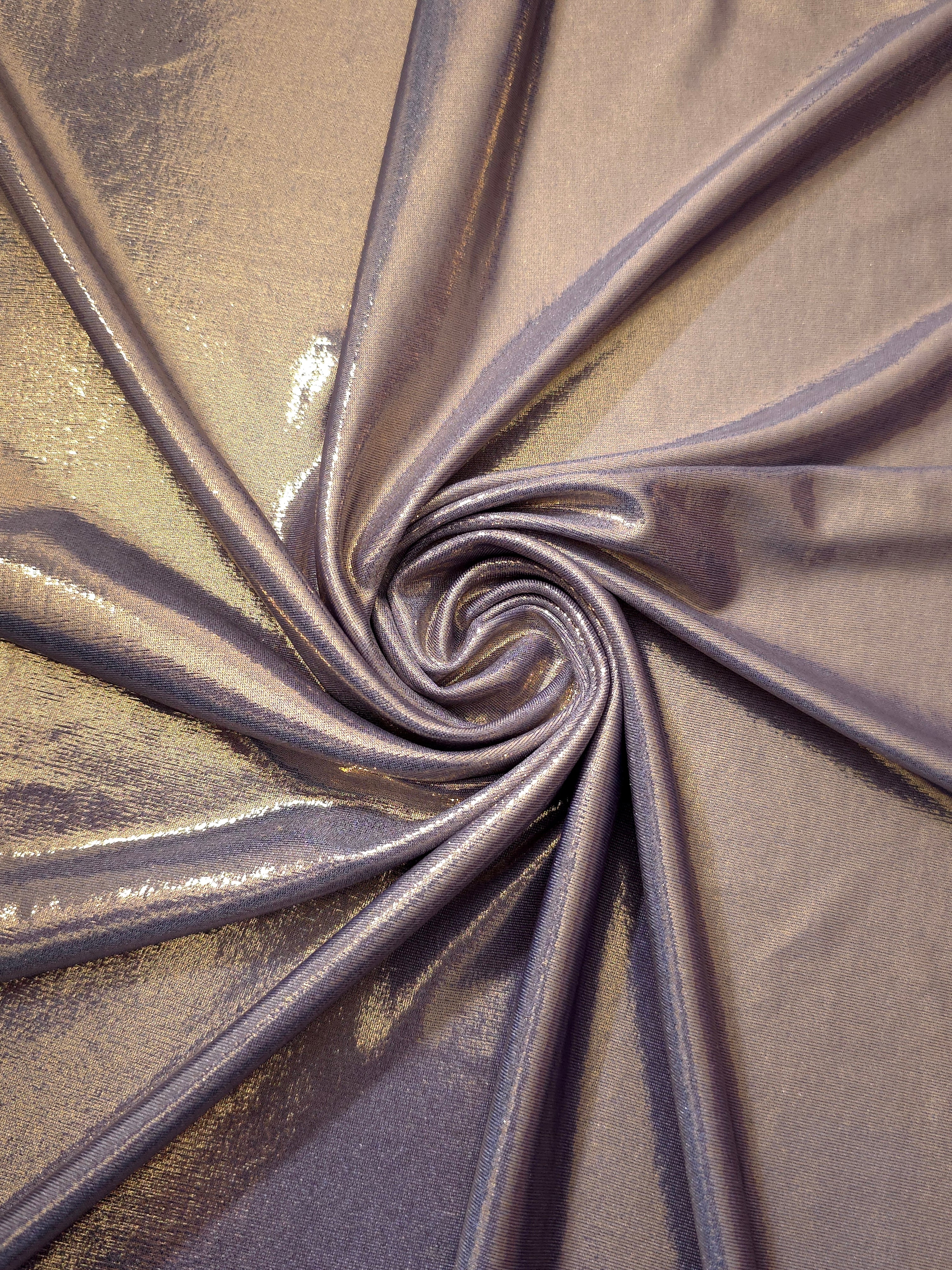Lavender Taupe metallic stretch fabric in a flowing swirl, emphasizing foil shimmer and drape for partywear and statement fashion