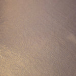 Detailed close-up of Lavender Taupe foiled spandex fabric showing its luminous metallic surface and fine reflective texture