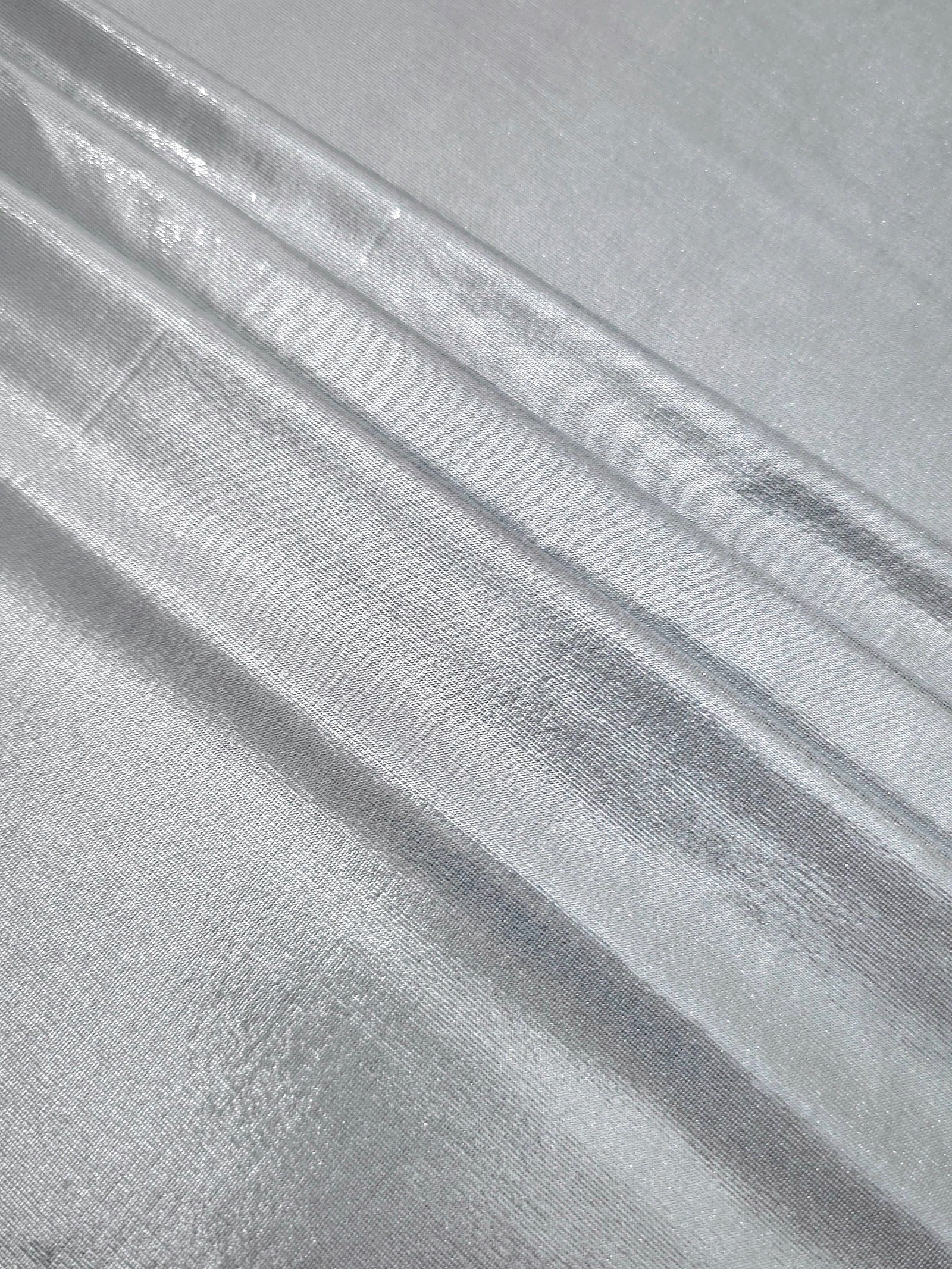 Light Silver Gray foiled spandex arranged in layered folds, displaying shimmer and soft structure for skirts, tops and performancewear