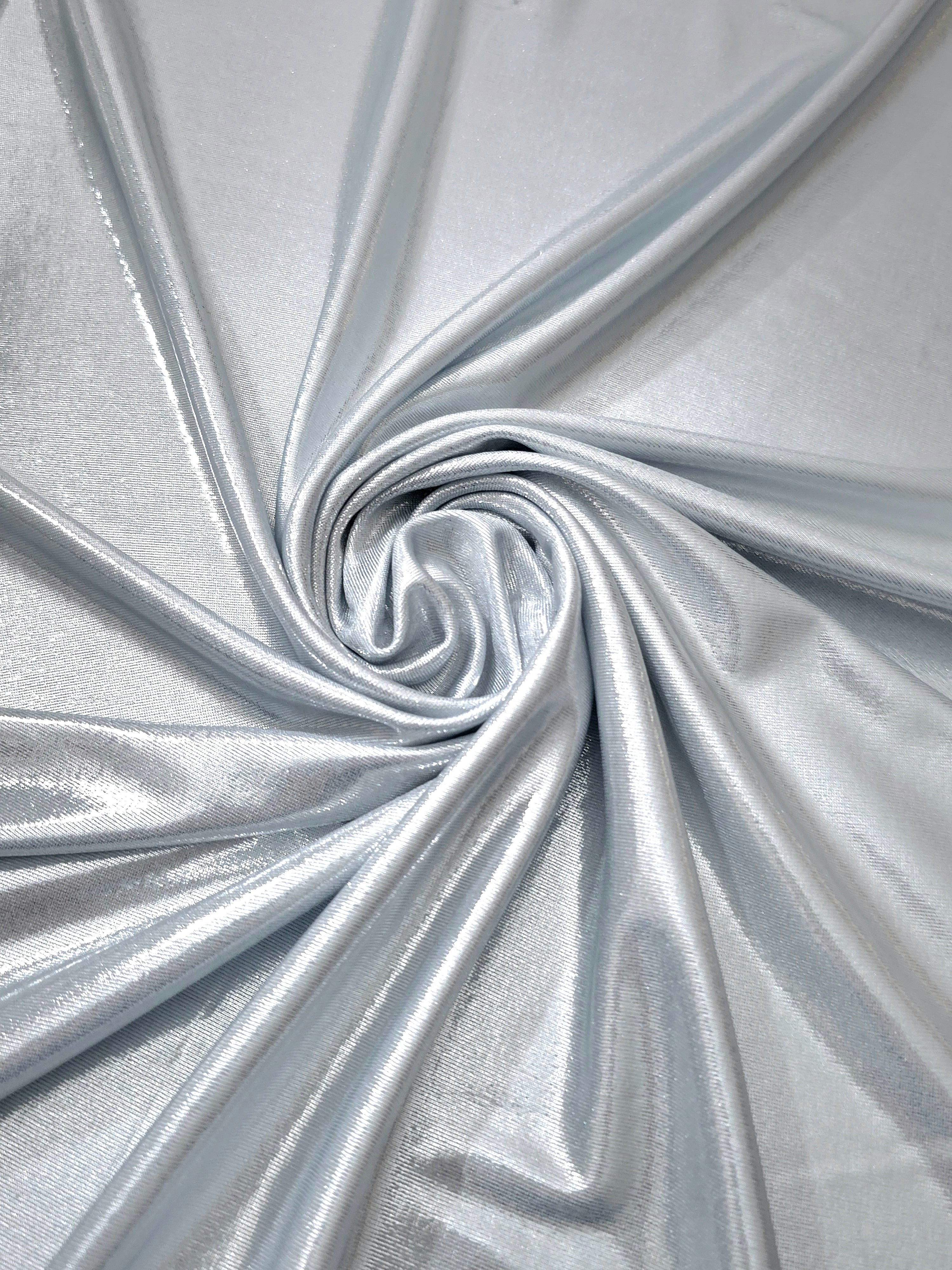 Flowing swirl of Light Silver Gray metallic stretch fabric, showing dynamic foil reflection for stagewear, skirts and creative fashion