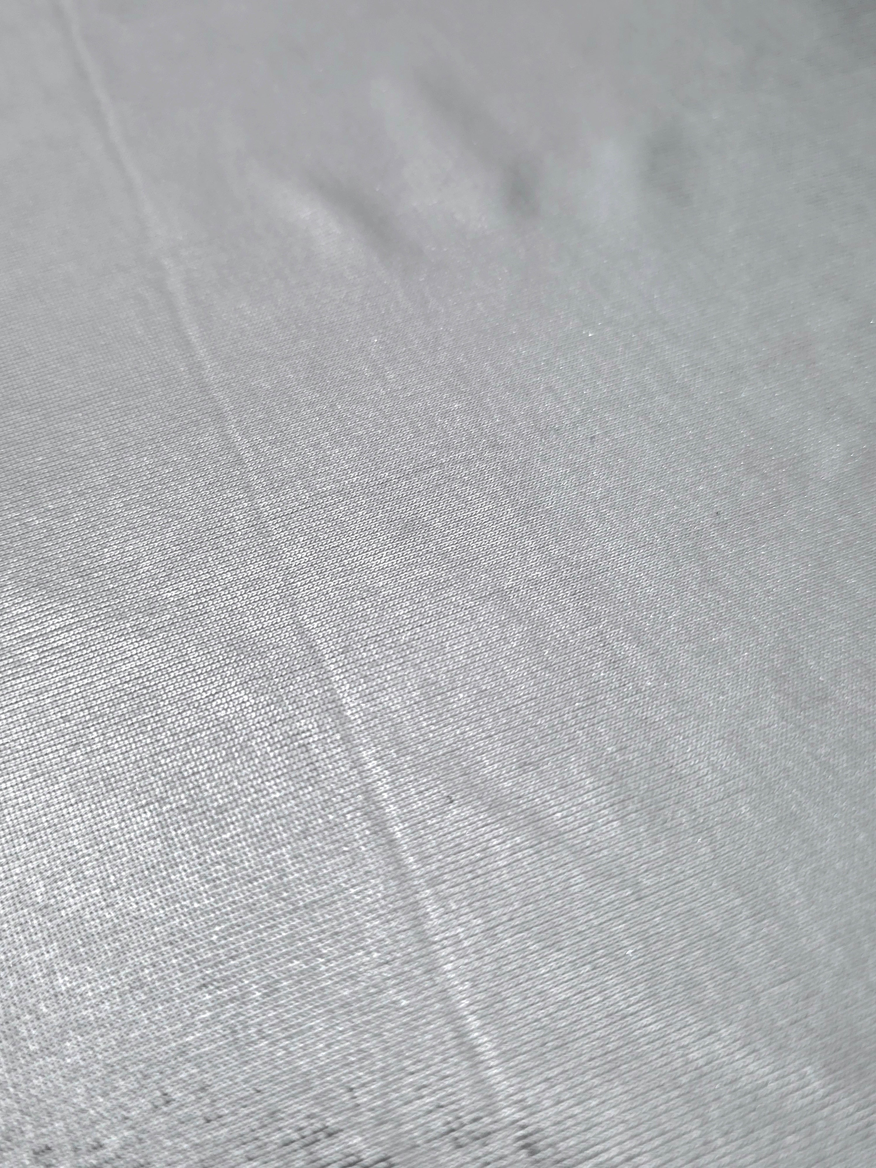 Light Silver Gray foiled stretch fabric texture close-up, displaying metallic reflection and fine surface character for apparel design