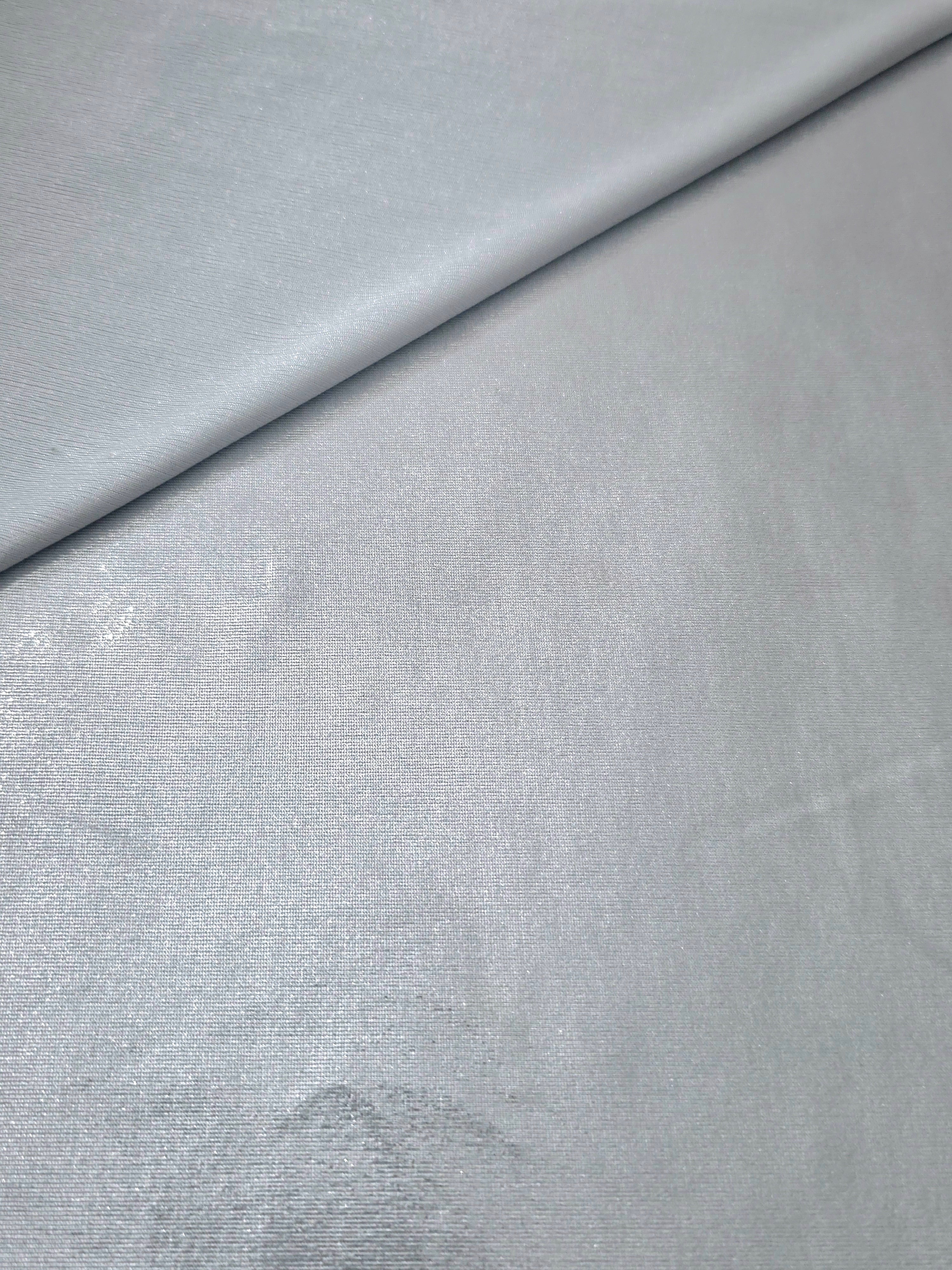 Softly folded Light Silver Gray foiled spandex showing metallic shine and flexible hand for costumes, eveningwear and creative sewing