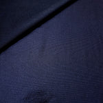 Soft fold of Midnight Navy Blue metallic foiled spandex highlighting reflective sheen and supple movement for dresses and stagewear