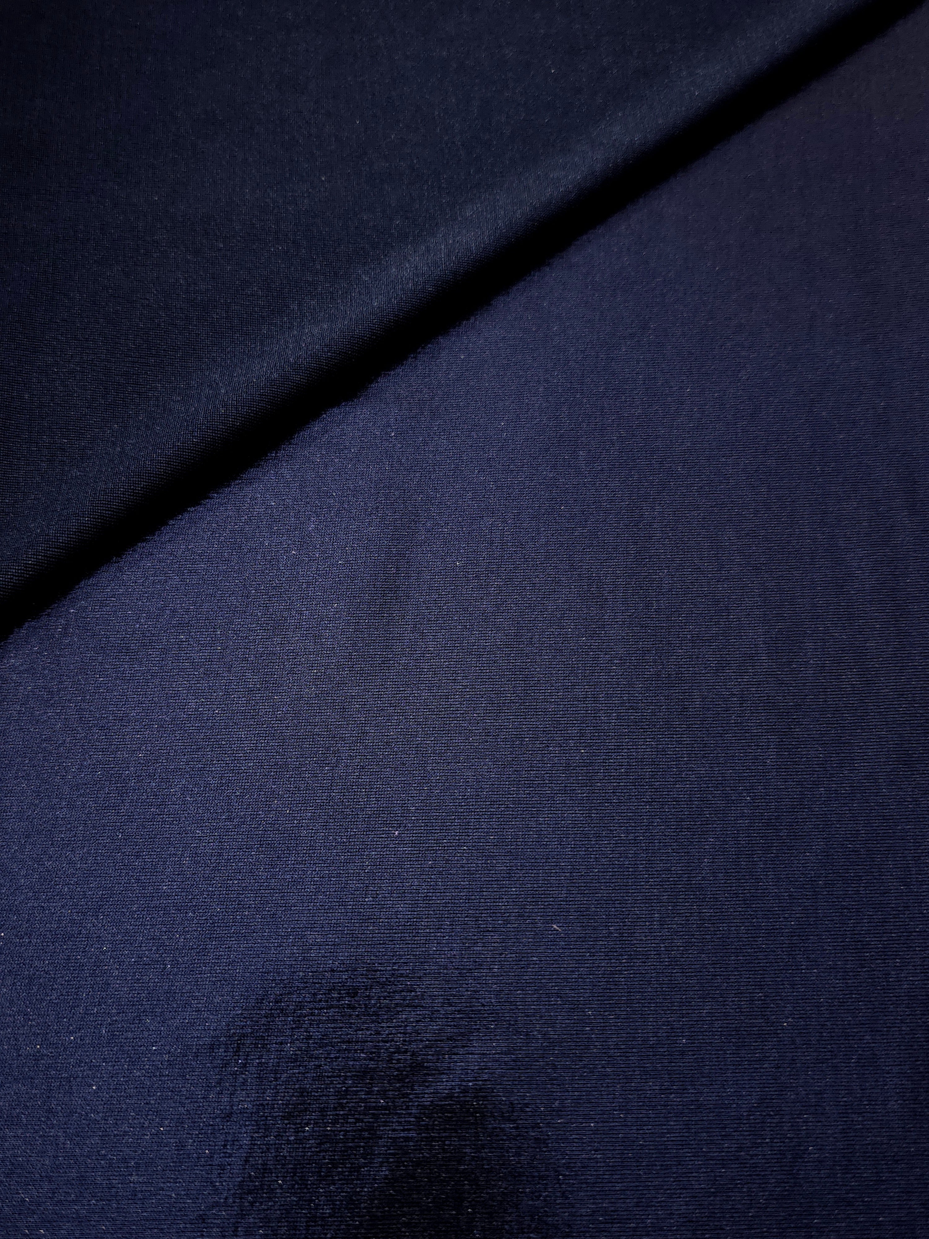Soft fold of Midnight Navy Blue metallic foiled spandex highlighting reflective sheen and supple movement for dresses and stagewear