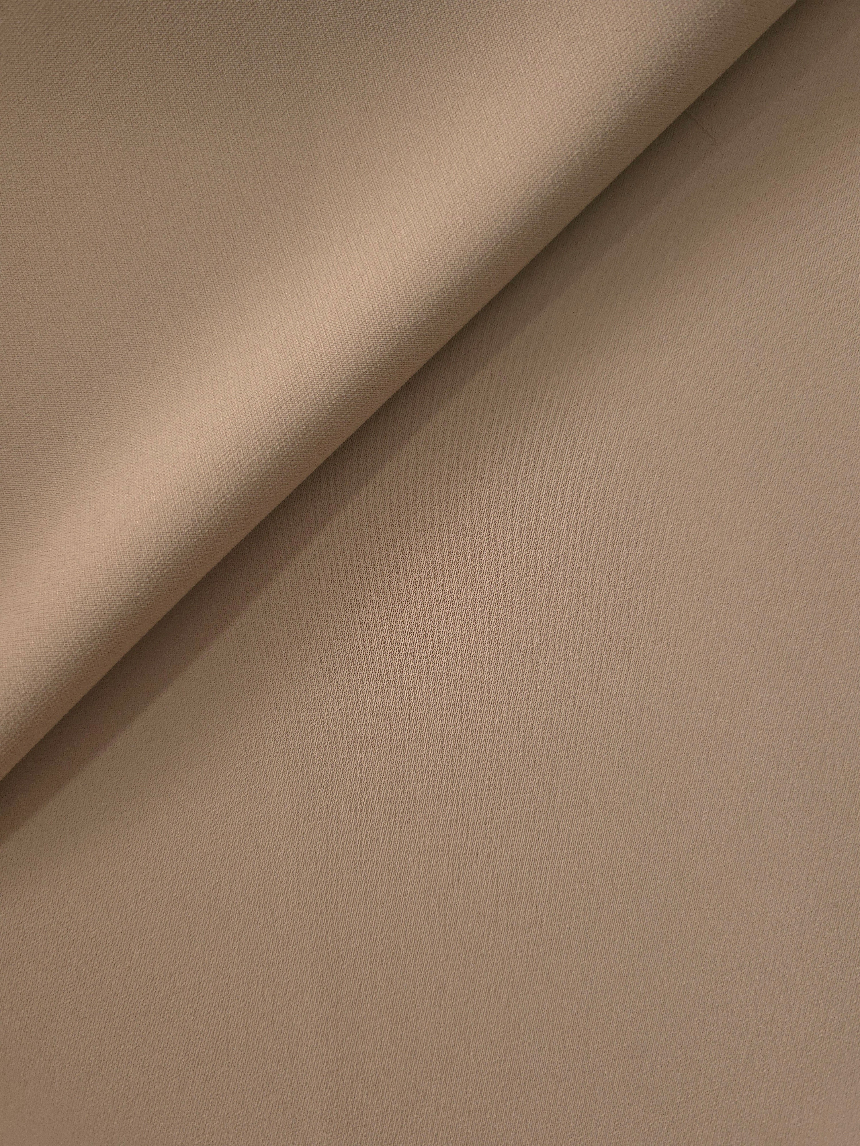 Soft fold of Mocha Taupe polyester crepe showing fluid dressmaking drape for dresses, skirts and blouses