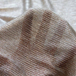 Detailed view of Moonlight gold semi-sheer stretch tulle fabric showing shimmer and texture