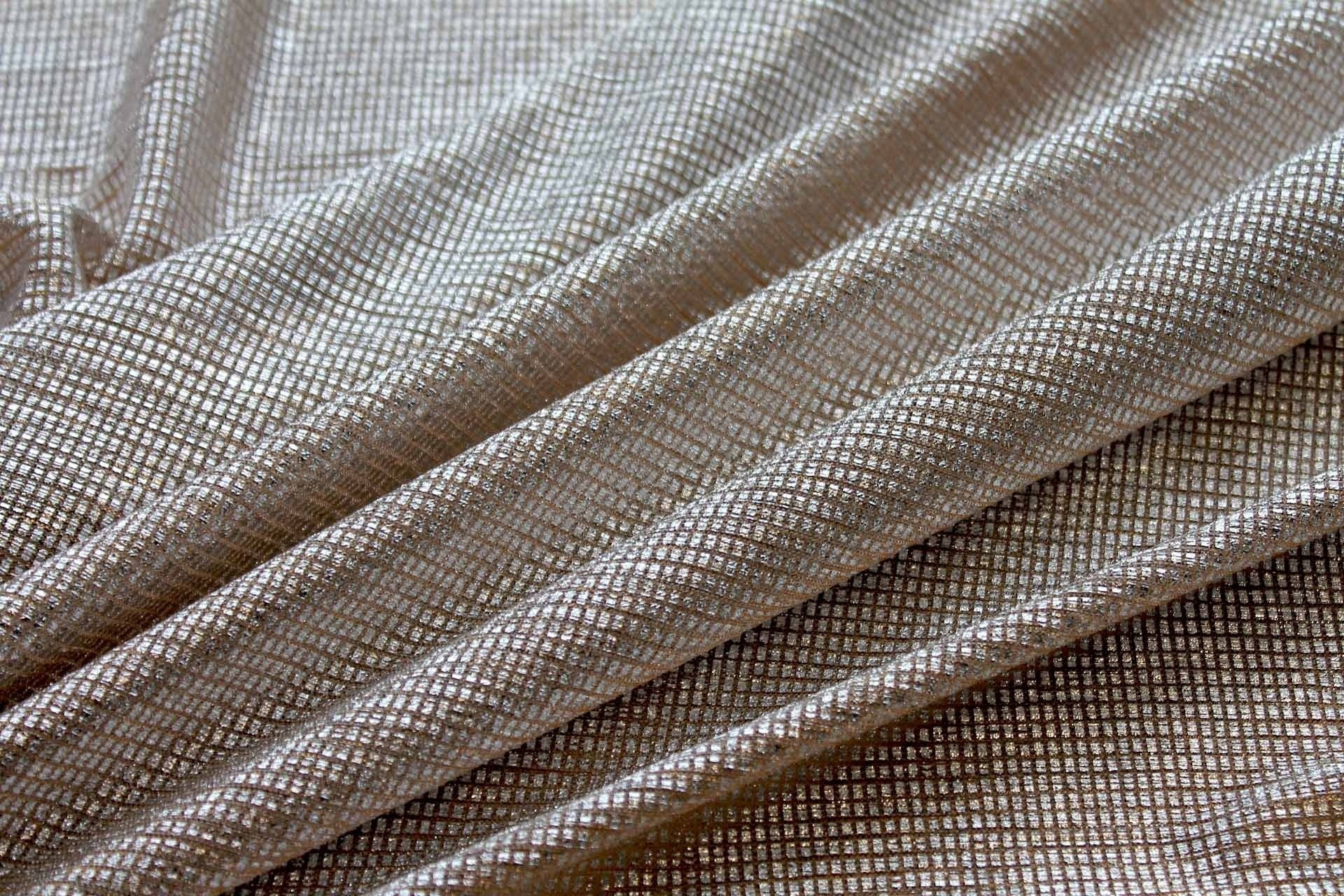 Moonlight gold stretch tulle fabric with silver foil shown in a soft draped view