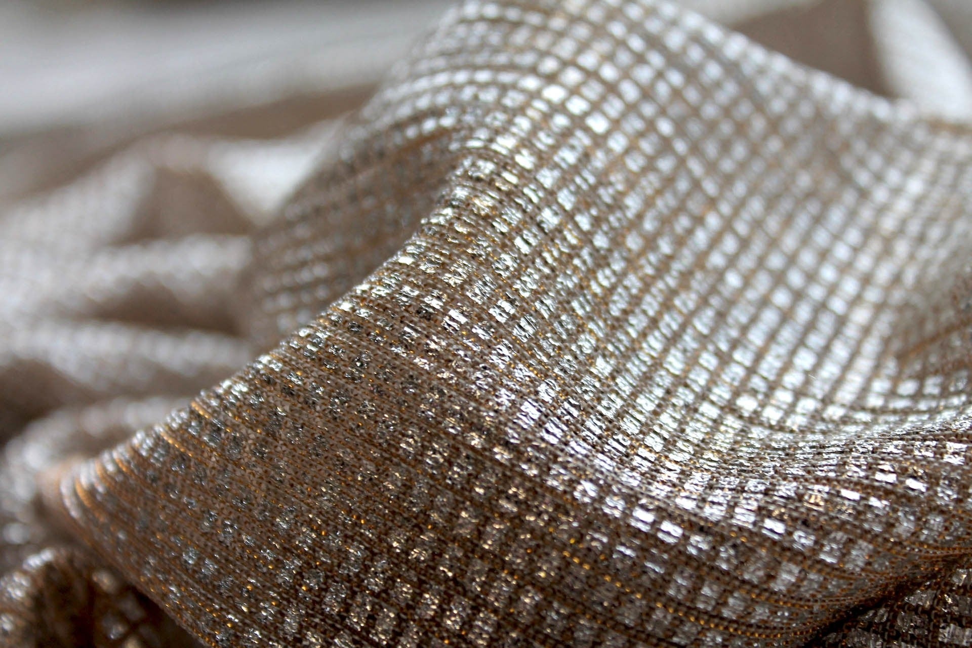 Close-up of Moonlight gold sheer shimmer tulle fabric with silver square foil texture