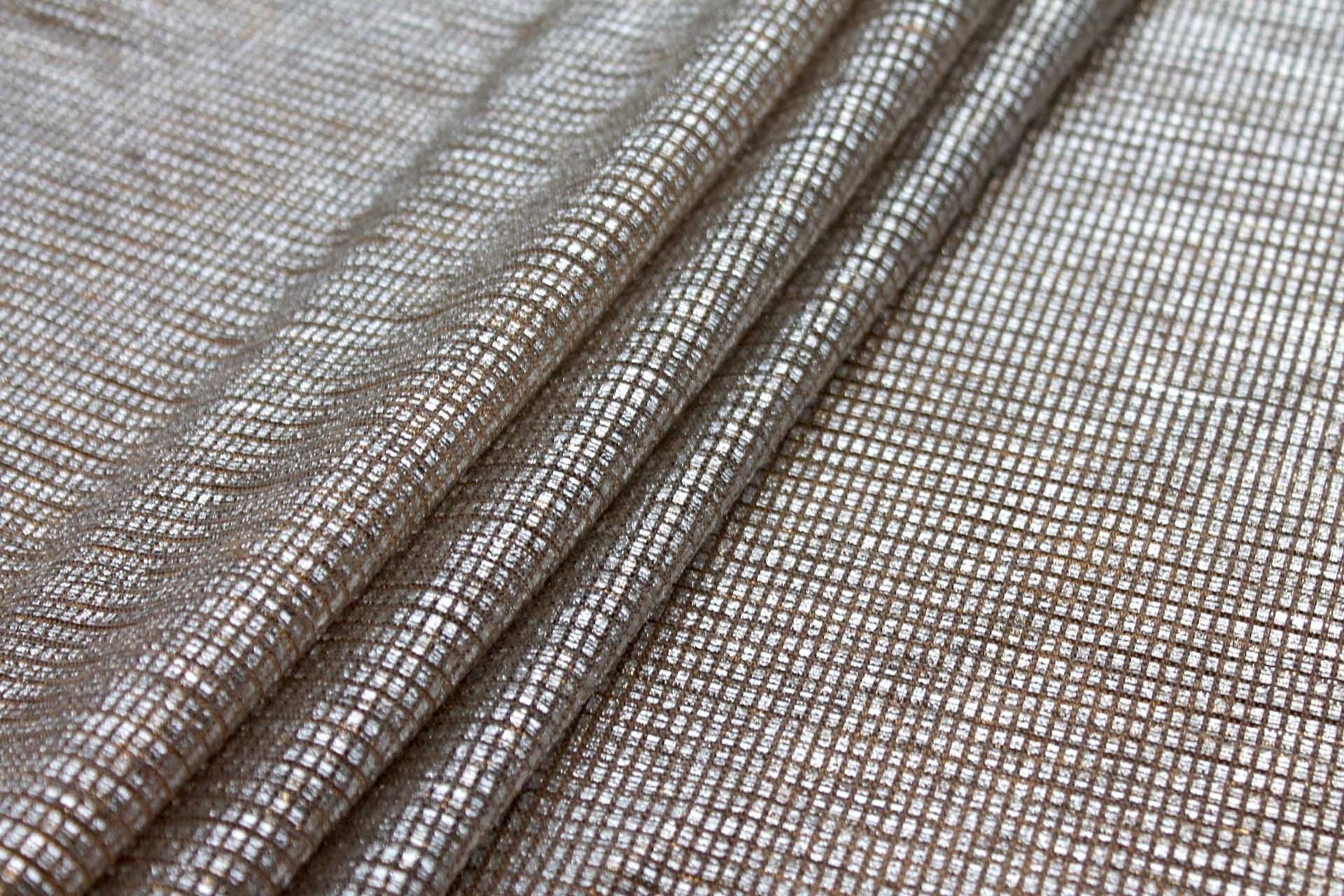 Flat lay of Moonlight gold shimmer stretch tulle fabric with silver foil accents