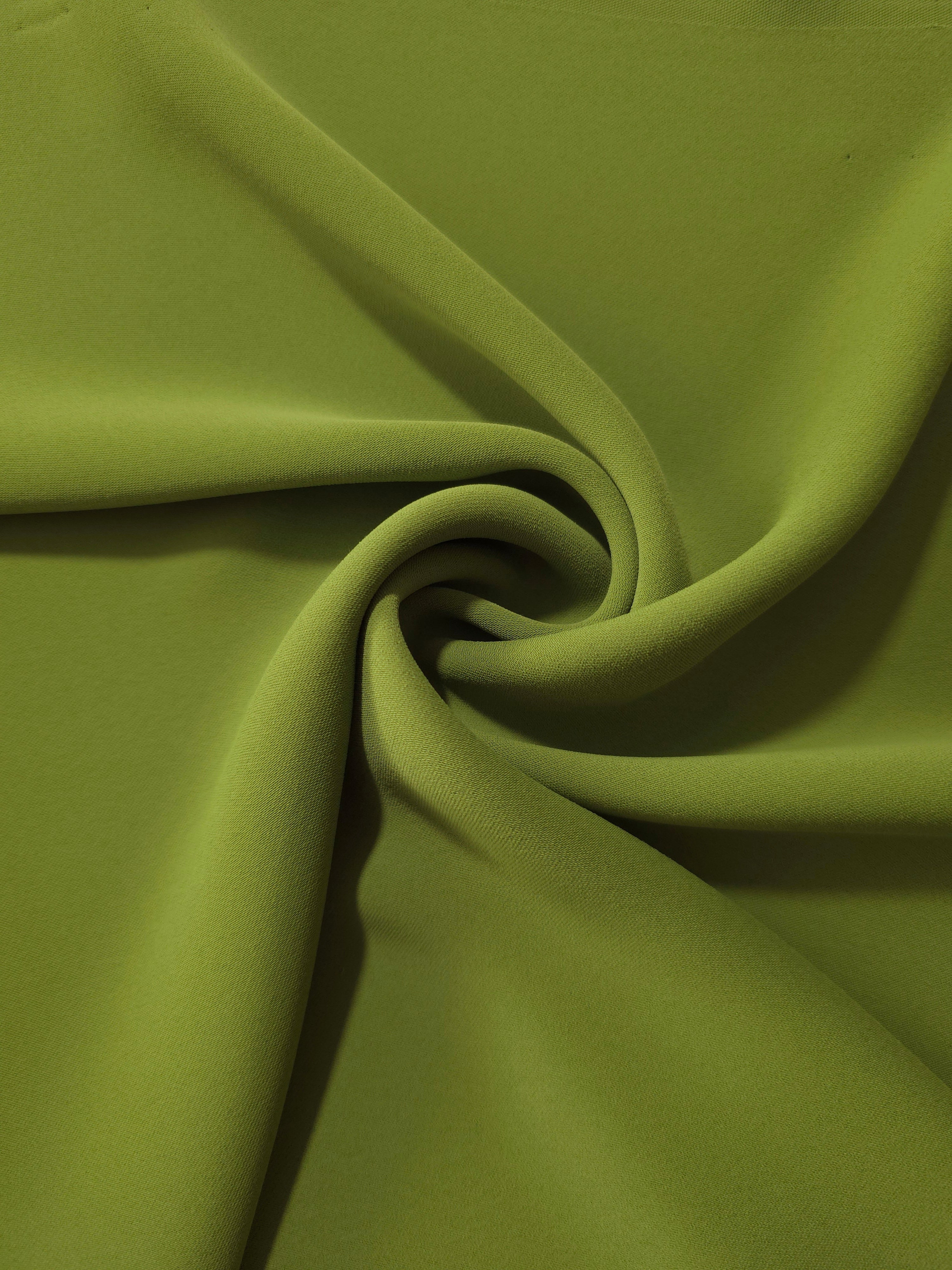 Moss Green opaque polyester crepe in a spiral drape, showing flowing form for skirts and modest garments