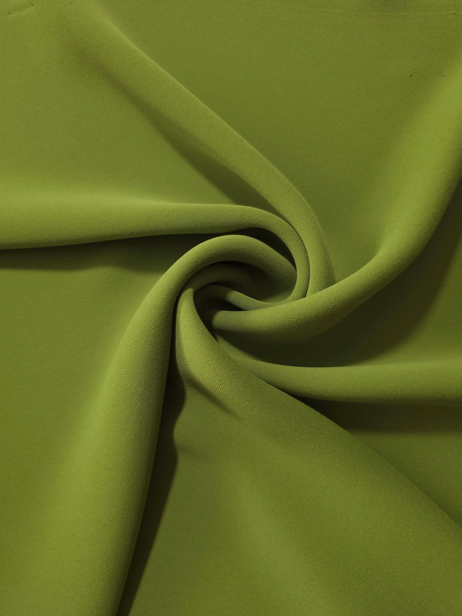 Moss Green opaque polyester crepe in a spiral drape, showing flowing form for skirts and modest garments