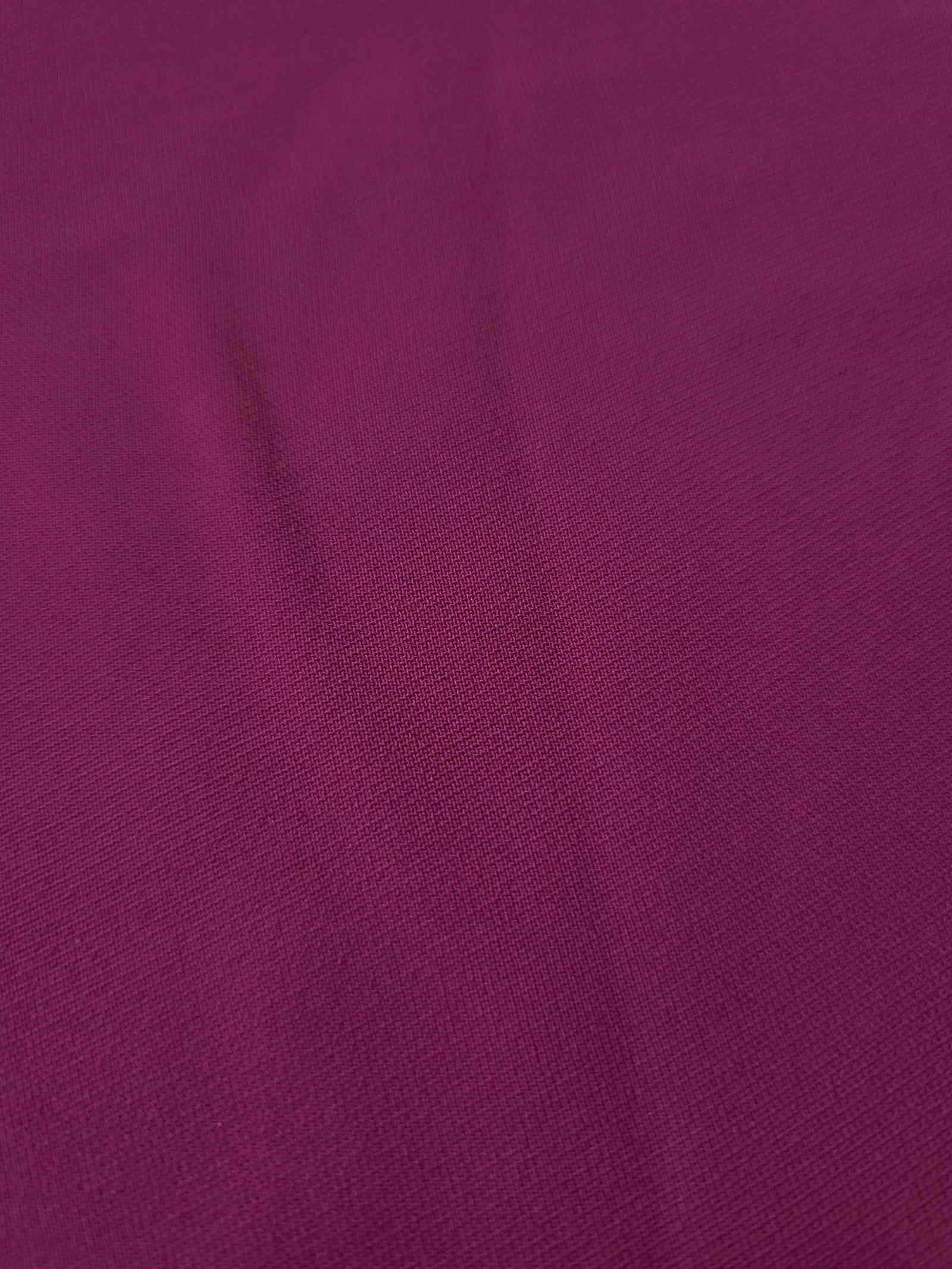 Close-up of Mulberry Purple 100% mechanical polyester crepe showing fine woven texture and a silky-soft hand feel