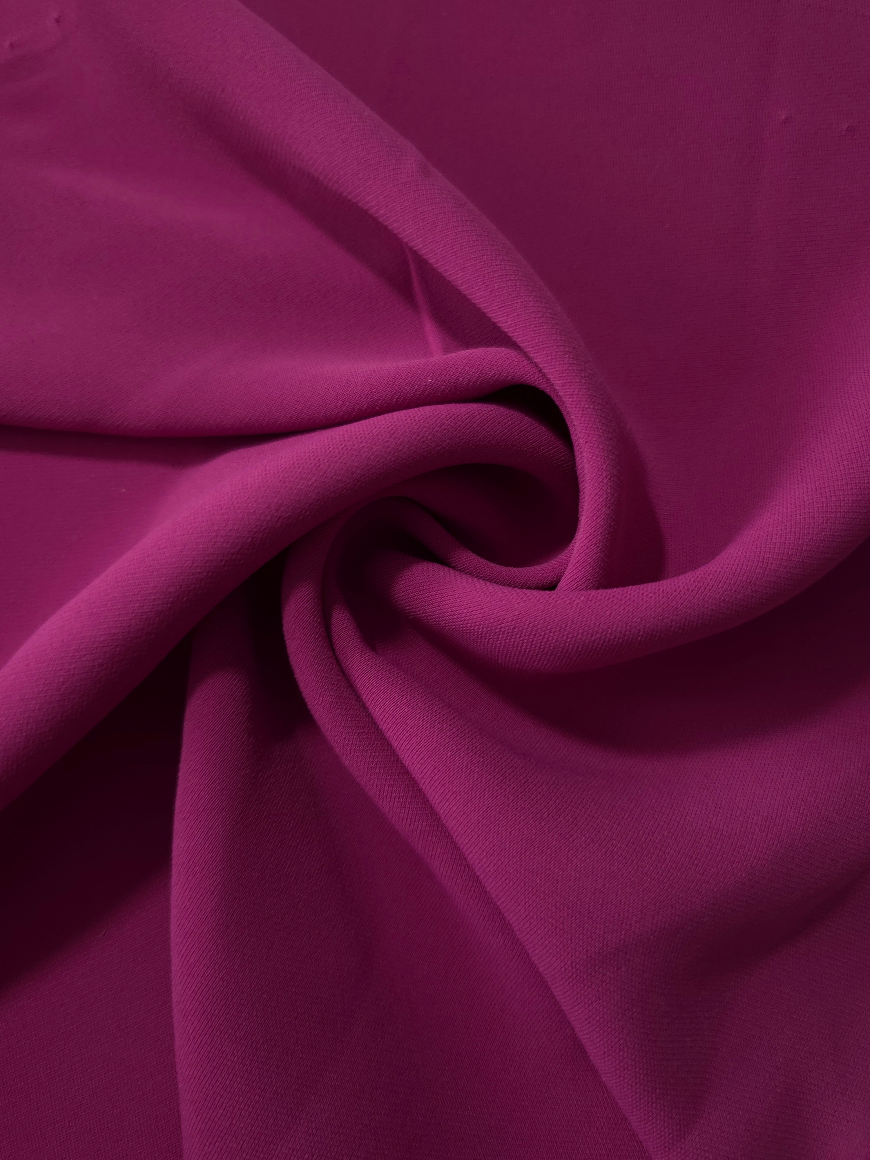 Mulberry Purple polyester crepe arranged in a flowing swirl, showing drape used for abayas and modest fashion