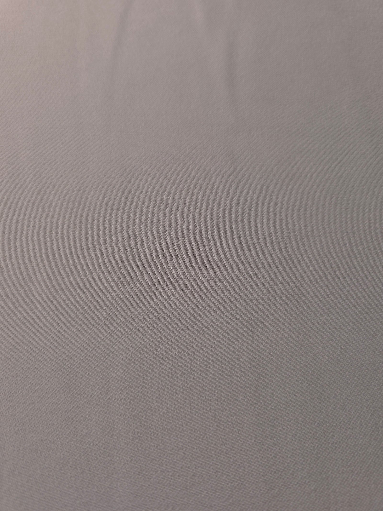 Close-up of Mushroom Greige 100% mechanical polyester crepe showing fine woven texture and a silky-soft hand feel